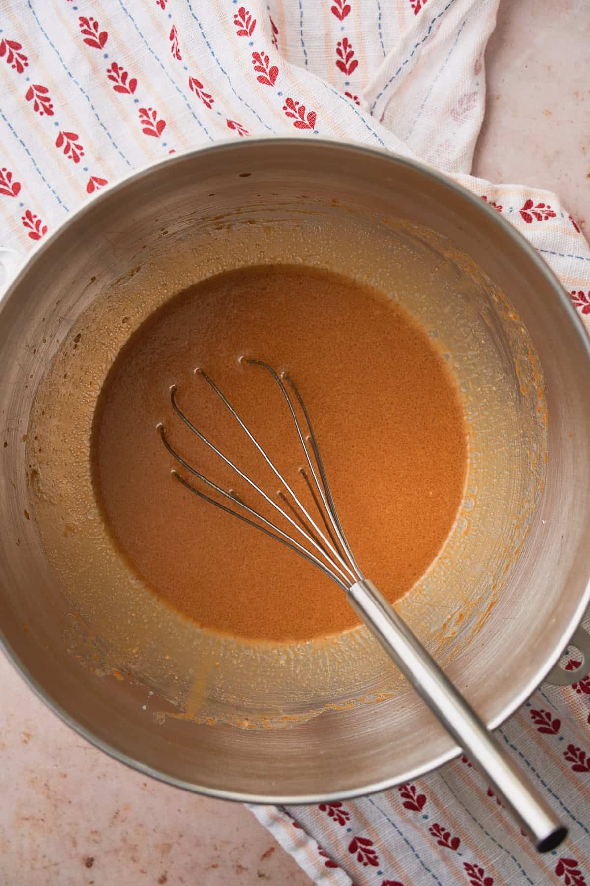 Foamy activated yeast mixture in a bowl with molasses and milk. 