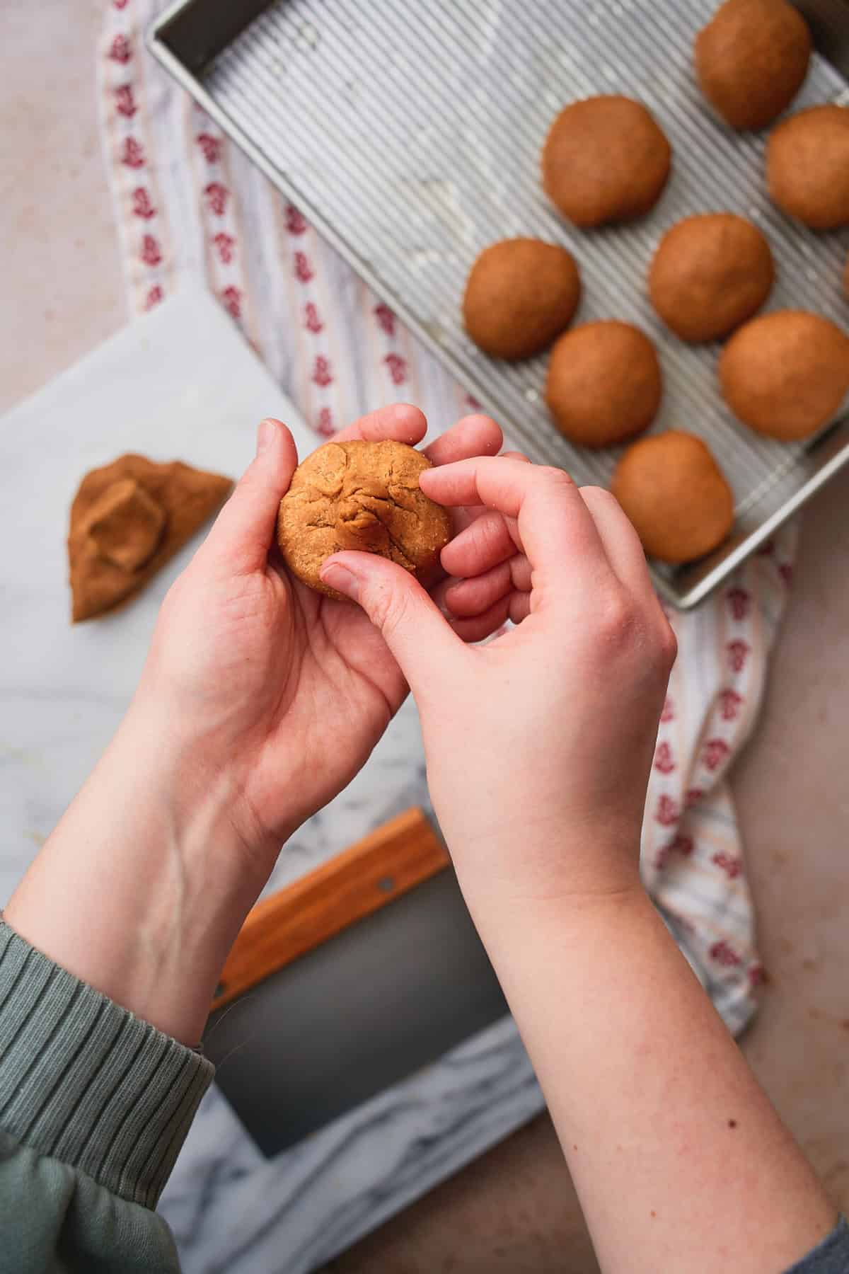 Hands pinching dough to creating a center near the back of the dough. 