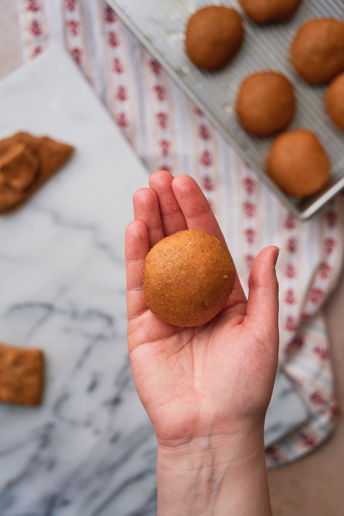 Soft ball of rye bread dough in a hand facing the camera.