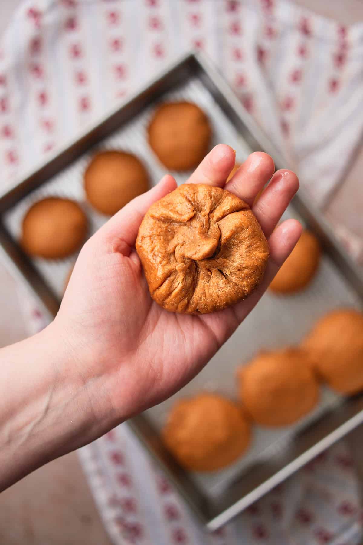 Hand holding a puffed up roll that needed the seem re-tucked in. 