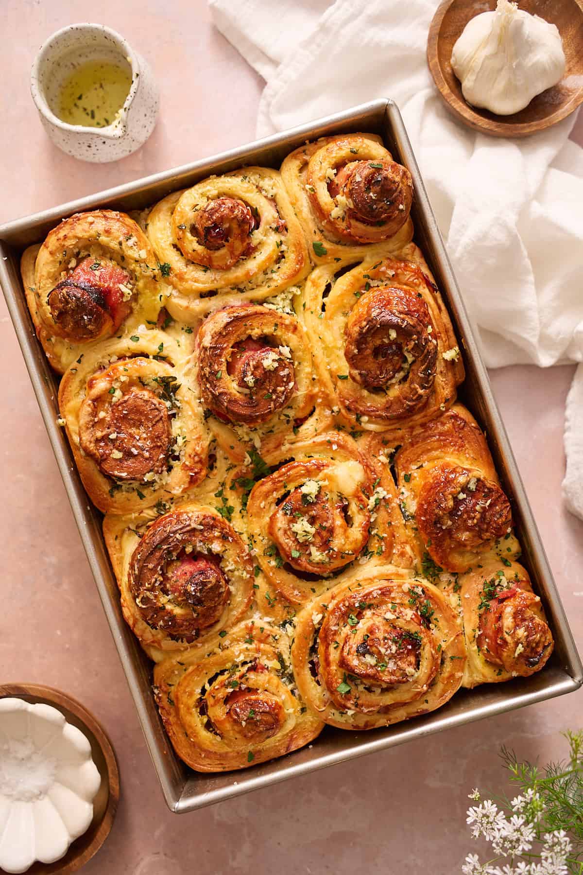 Tray of golden brown ham and cheese rolls with garlic butter.