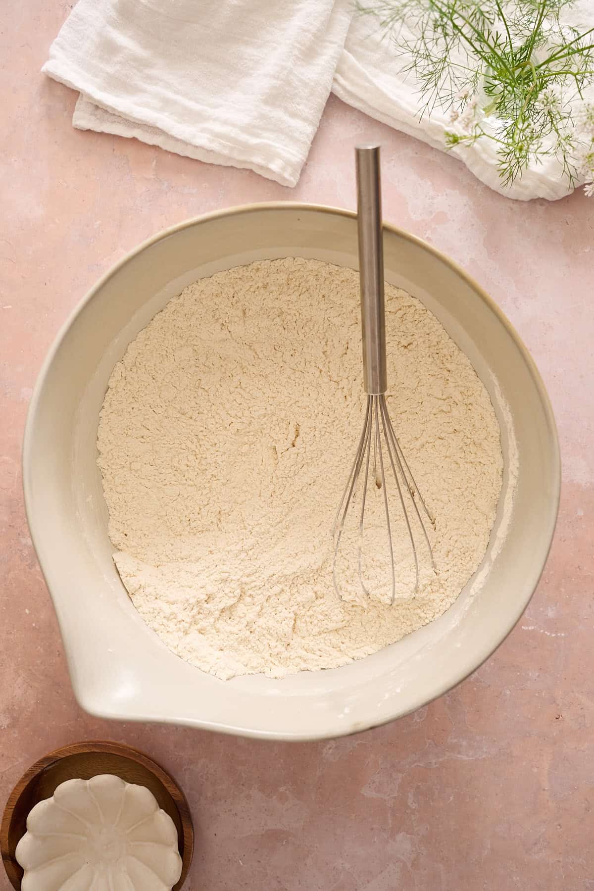 Flour, yeast, sugar and salt in a bowl being whisked.