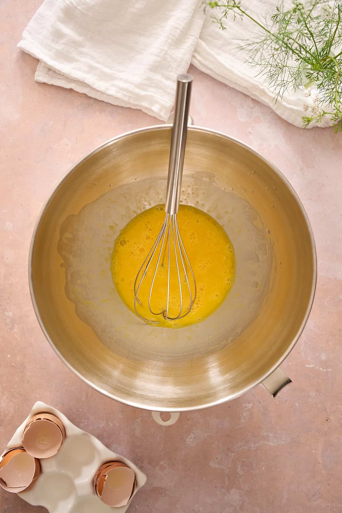 Whisked eggs in a metal mixing bowl.