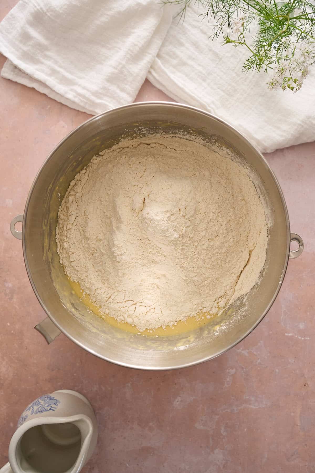 Flour added to the bowl of a stand mixer getting ready to be mixed. 