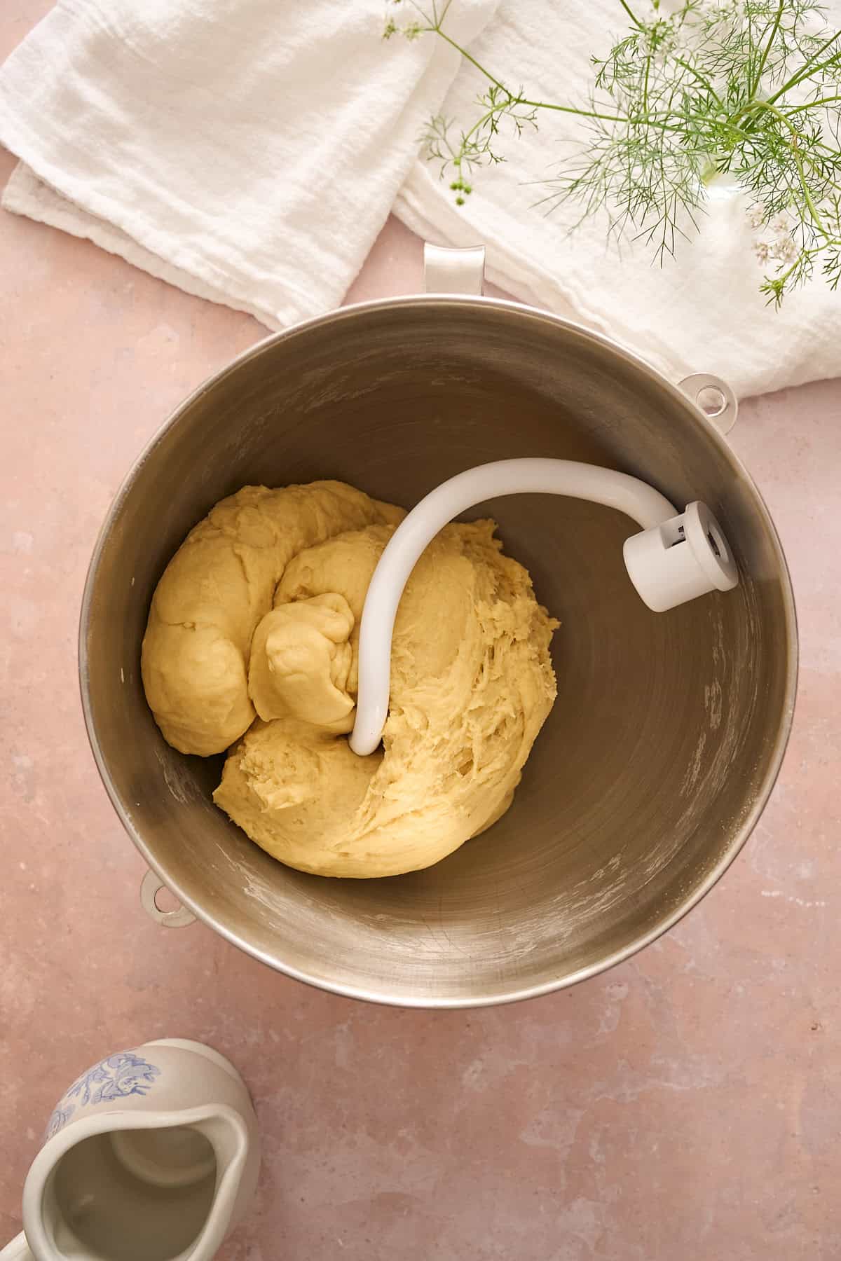 Kneaded dough ball in a stand mixer with a dough hook. 