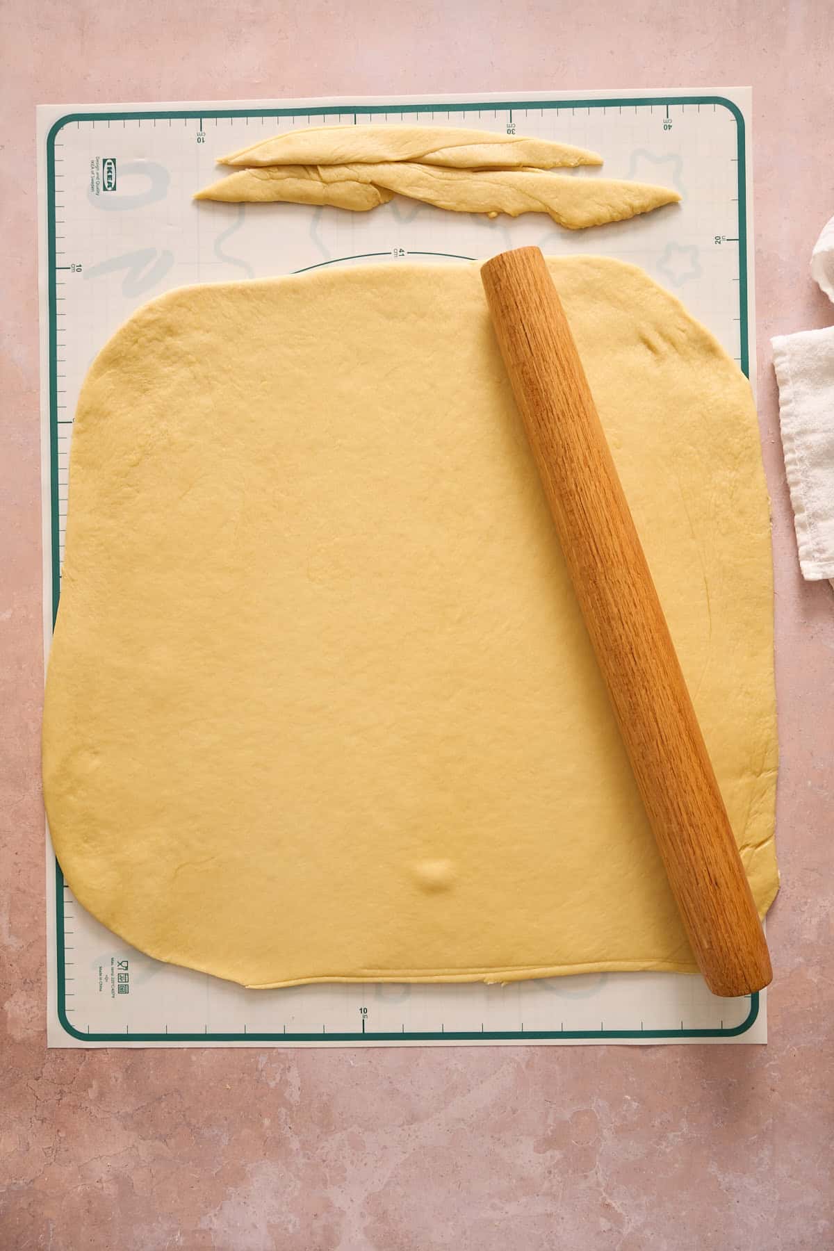 Dough rolled into a rectangle with the rolling pin and scraps cut off. 