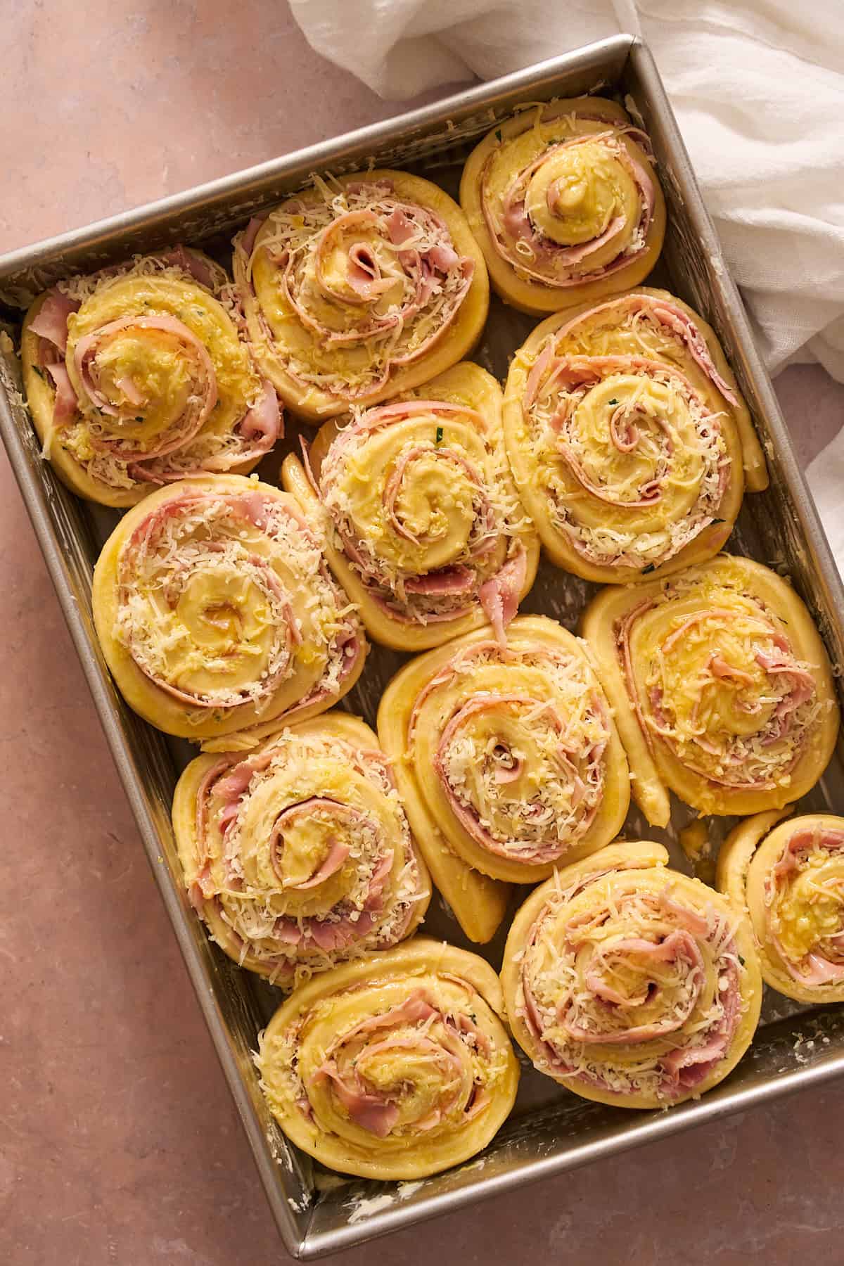 Puffy ham and cheese rolls brushed with egg wash and getting ready to bake. 