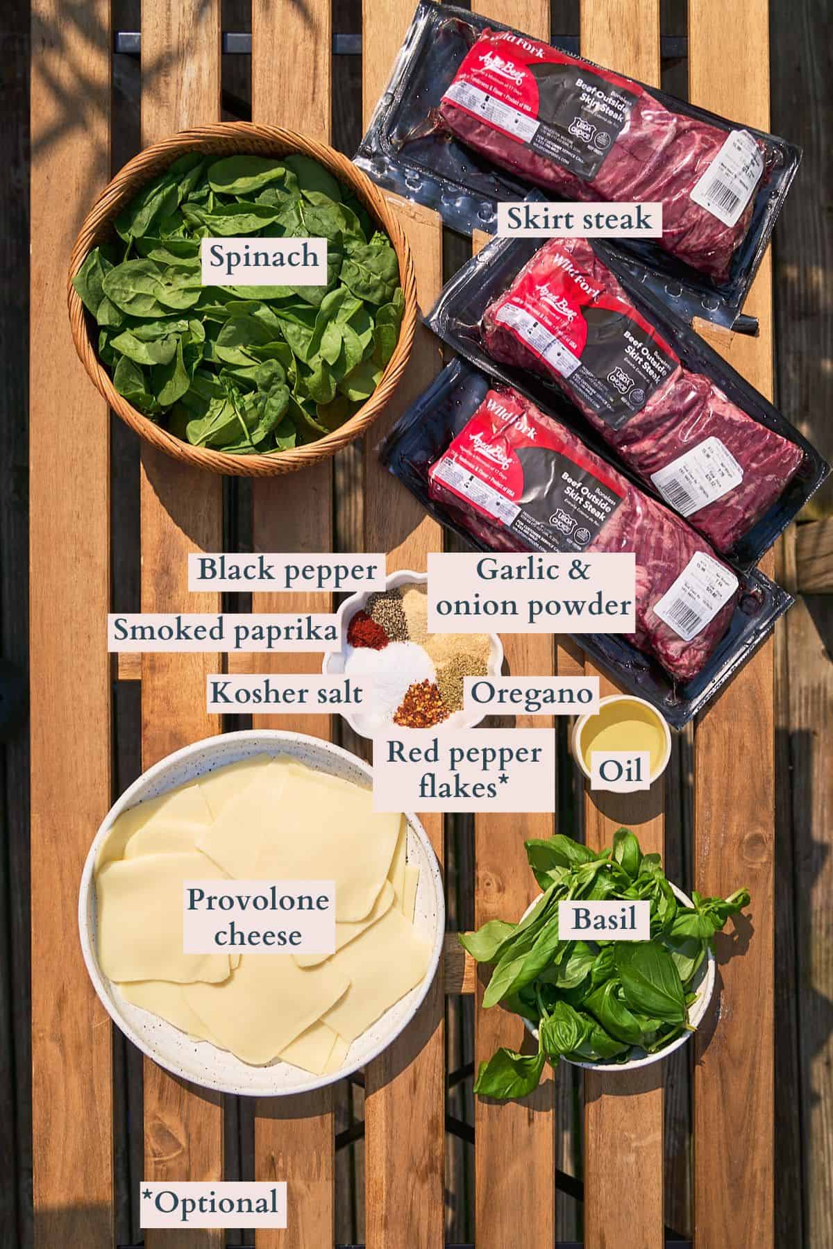 Ingredients to make skirt steak pinwheels laid out on a table and labeled to denote each ingredient.