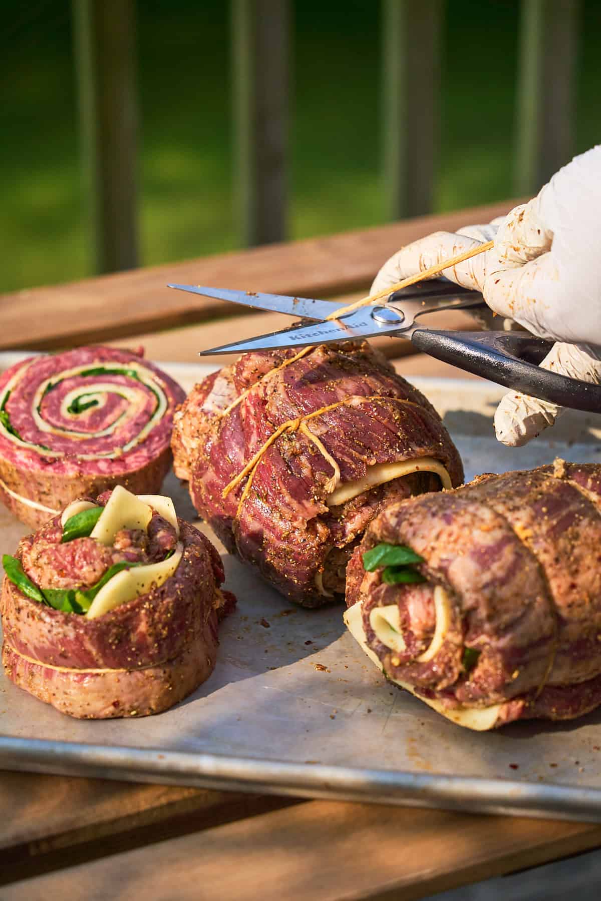 Hands cutting twine with scissors to leave less excess string.