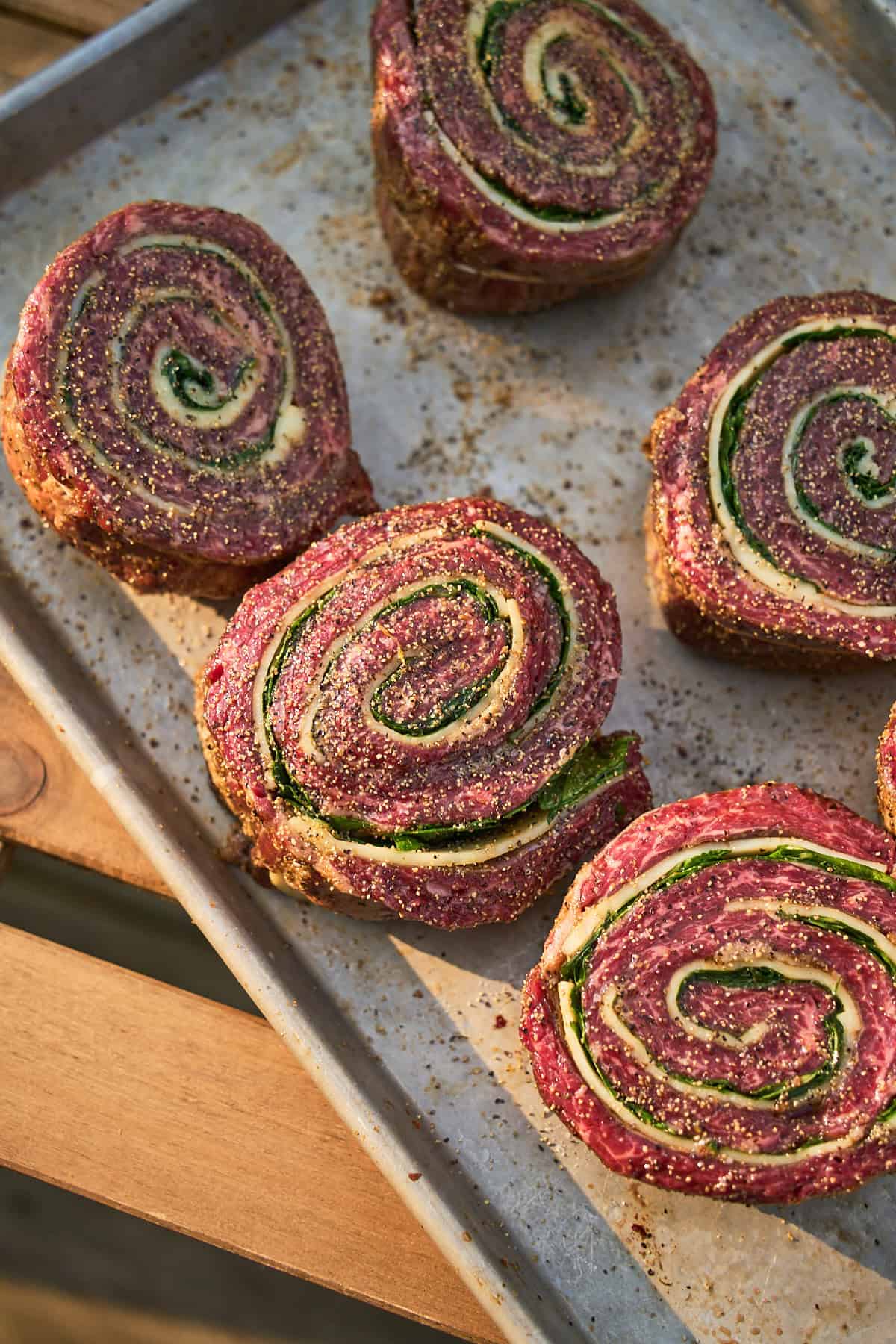 Steak pinwheels cut in half to show the rolled interior, then seasoned with salt and pepper.