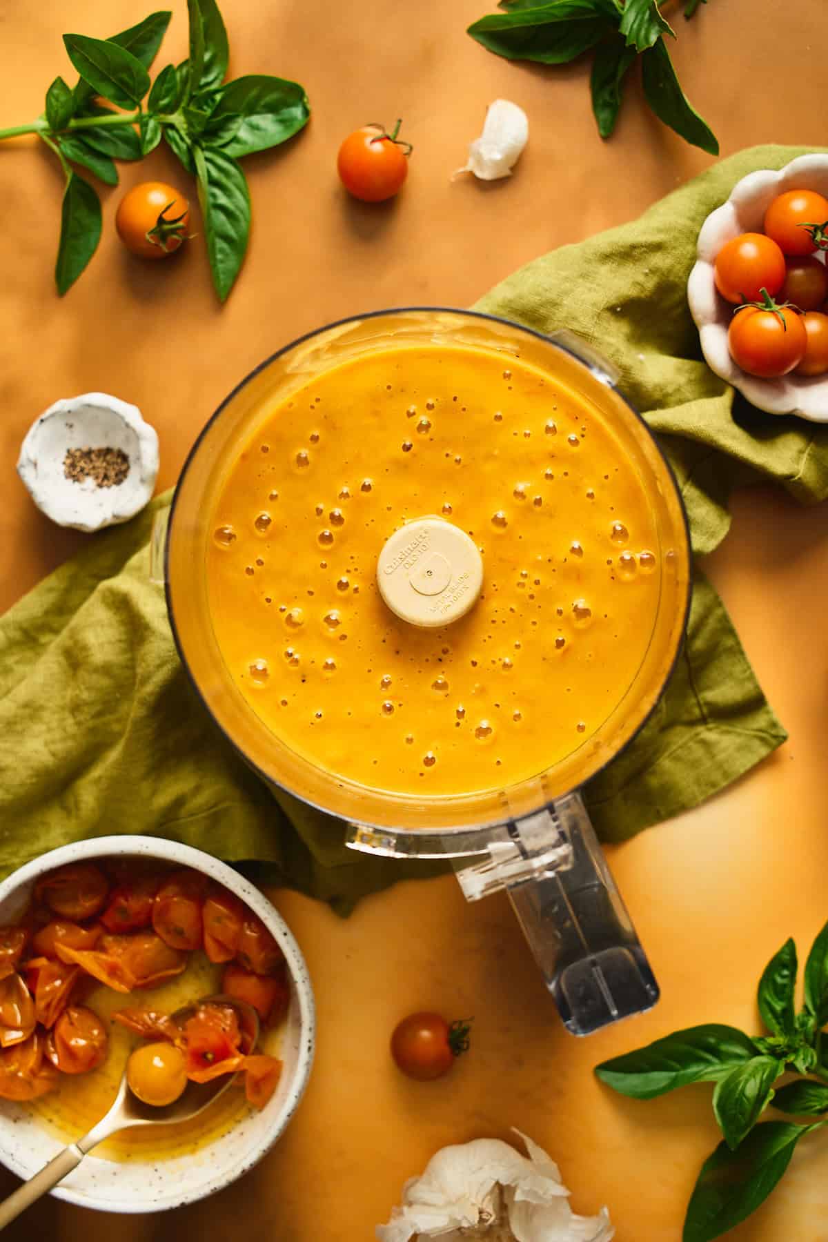 Pureed bright orangish-yellow tomato sauce in a food processor.