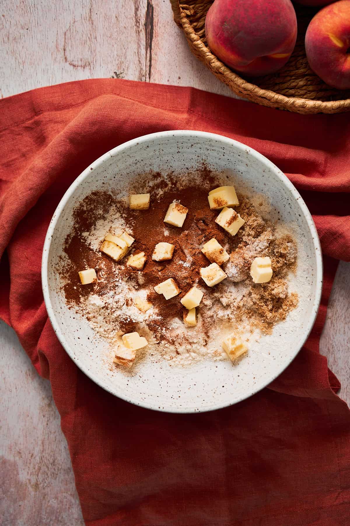 cold butter chunks in a bowl with brown sugar, cinnamon, flour, and salt.