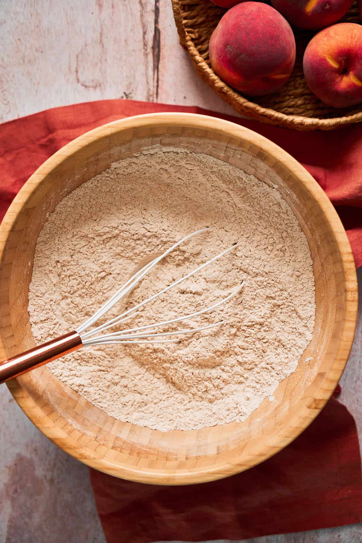 Whisking together dry ingredients in a wooden bowl to make cinnamon rolls.