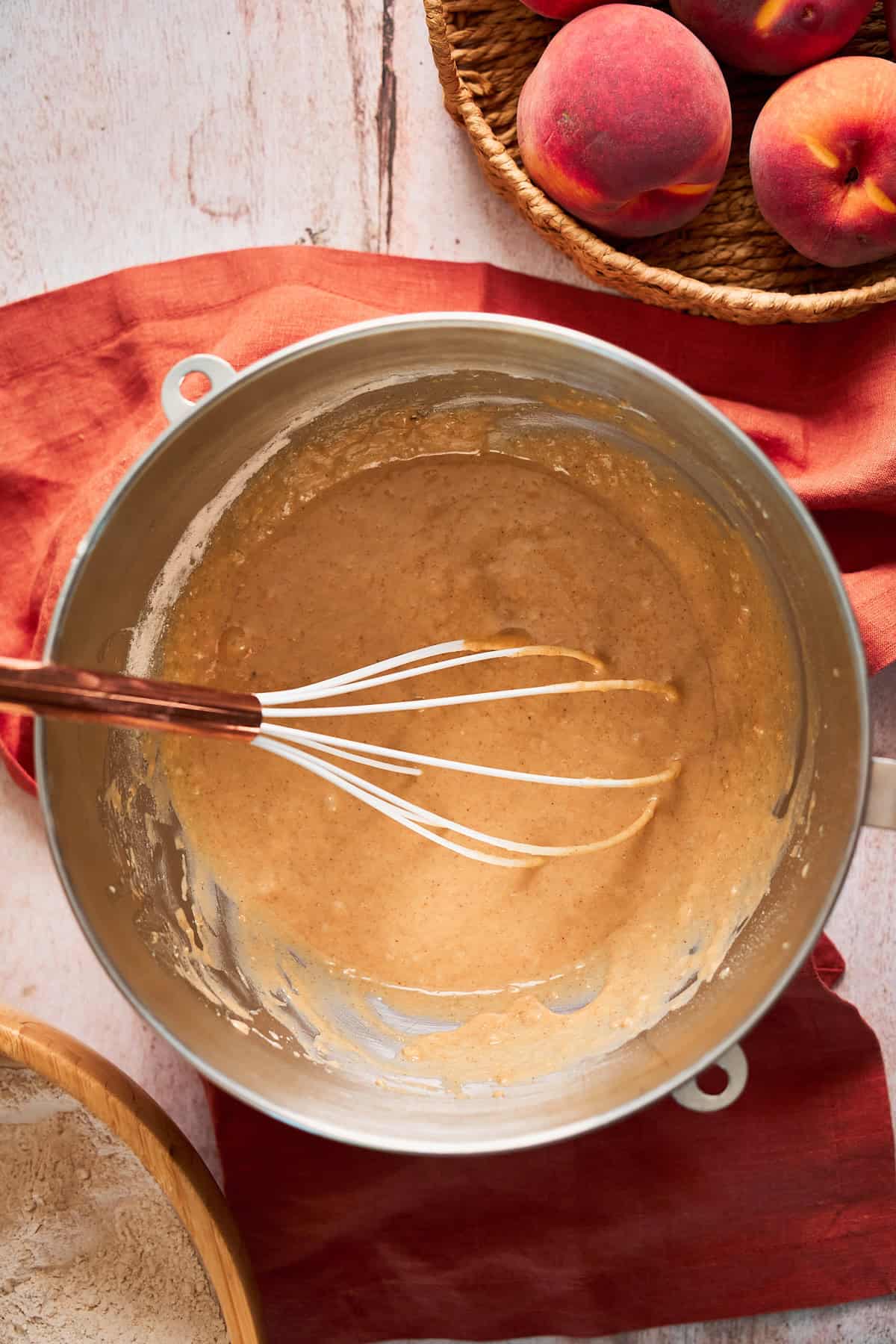 Flour whisked into wet ingredients to make cinnamon roll dough on a terra cotta colored linen napkin.