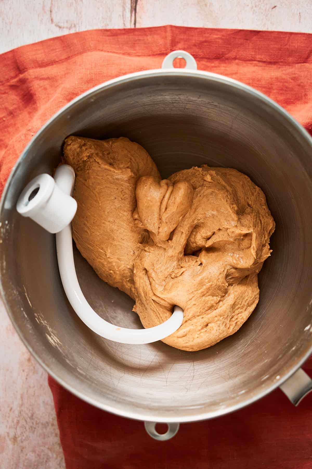 Kneaded dough for cinnamon rolls in a metal bowl.