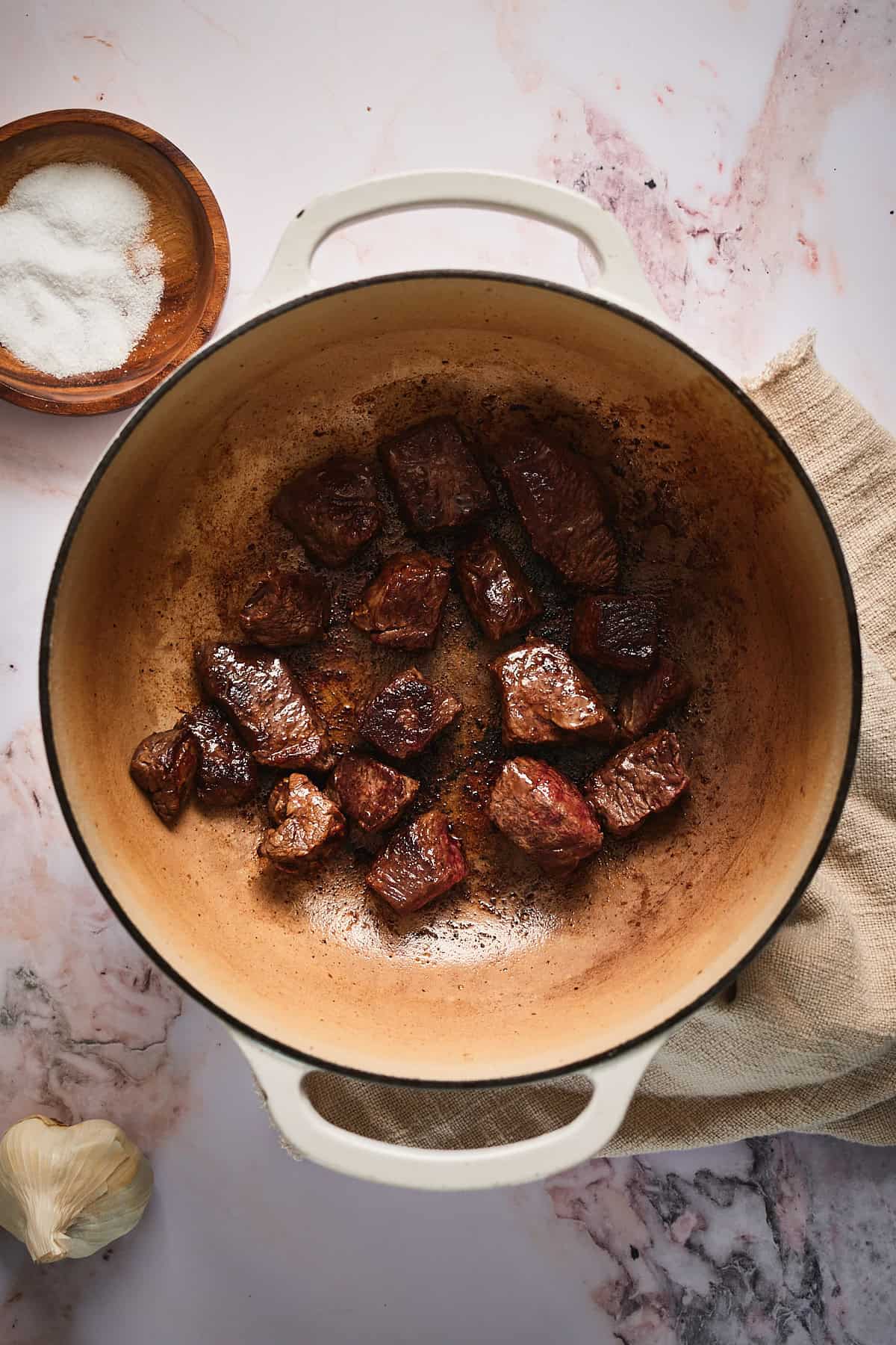 Browning pieces of beef chuck roast in a large Dutch oven.