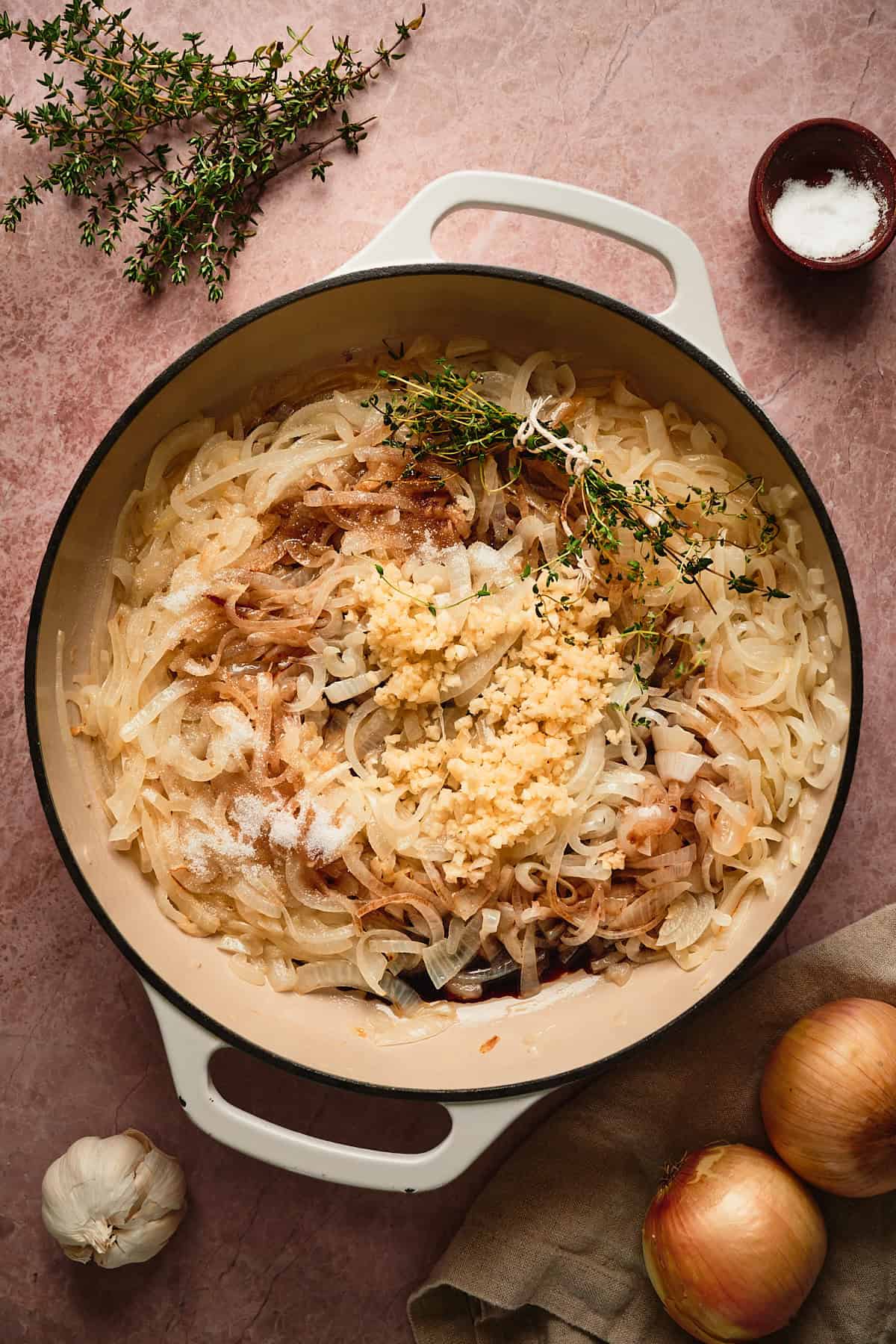 Onions cooking in a skillet with garlic, Worcestershire sauce, sugar, and thyme added to cook down. 