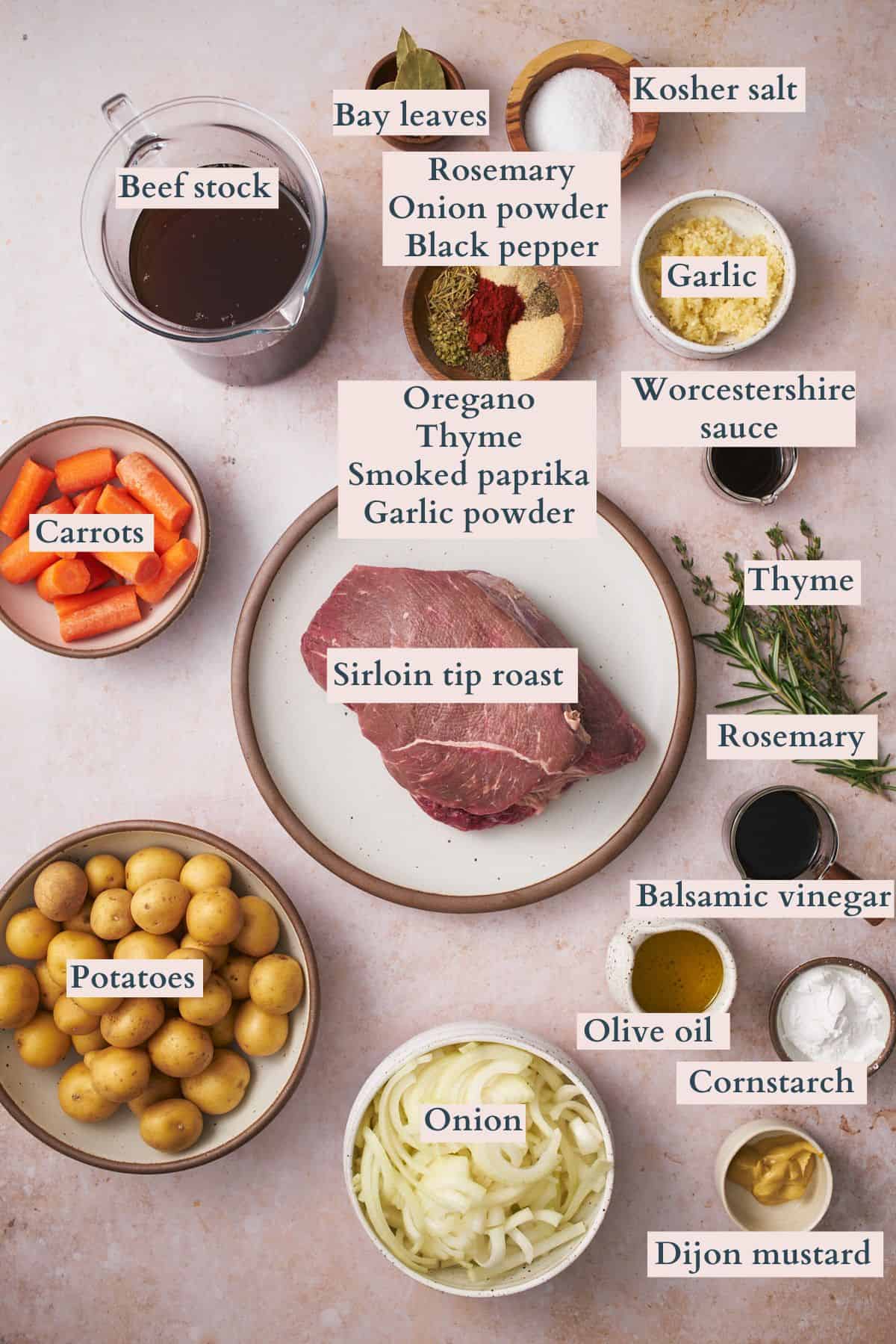 Ingredients to make a slow cooker sirloin tip roast laid out on a table and labeled to denote each ingredient.