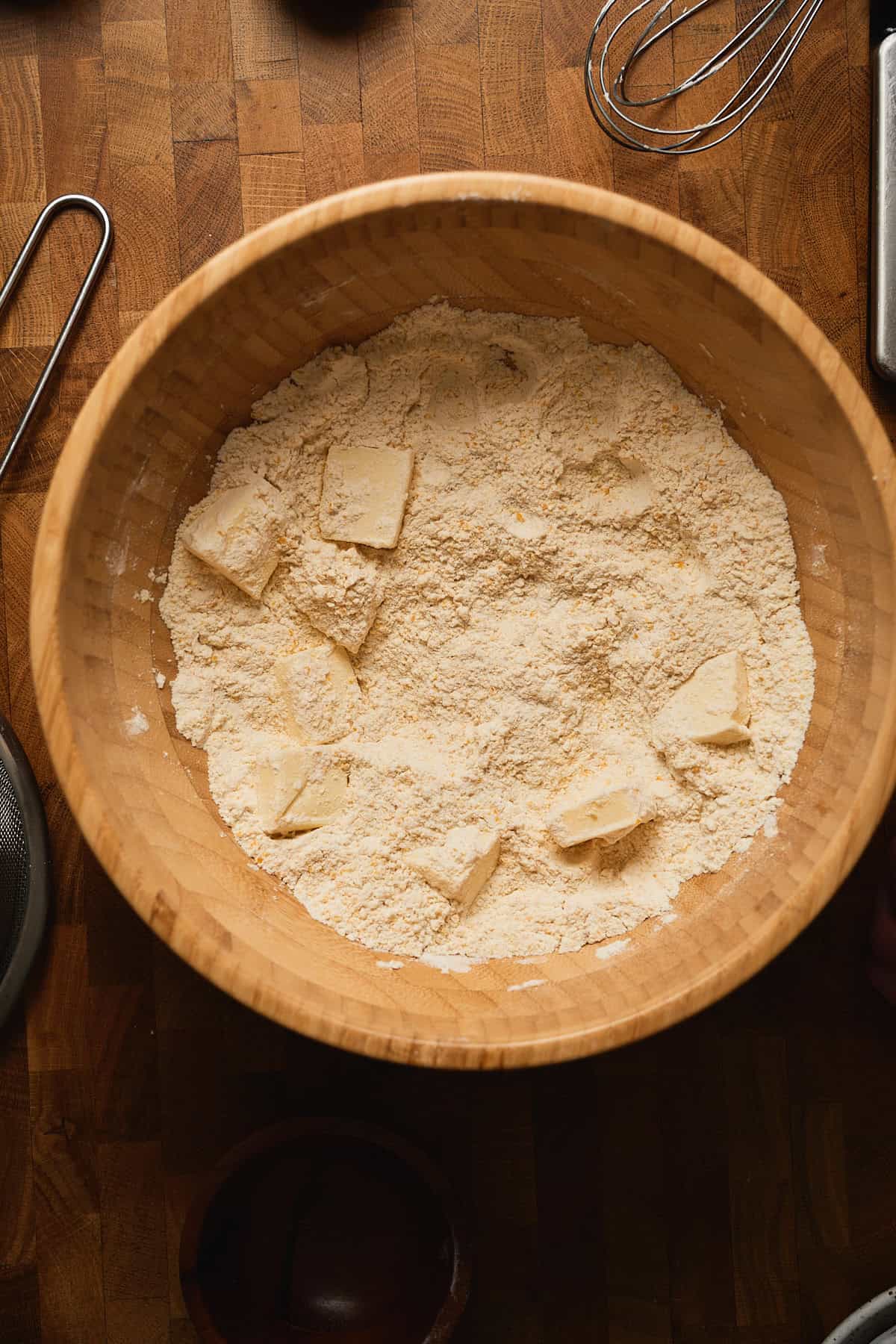 Flour and butter in a wooden mixing bowl for baking.