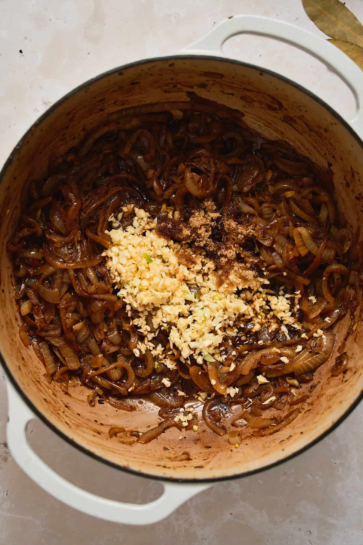 Onions that have begun to caramelize deeply, with brown sugar and garlic added.