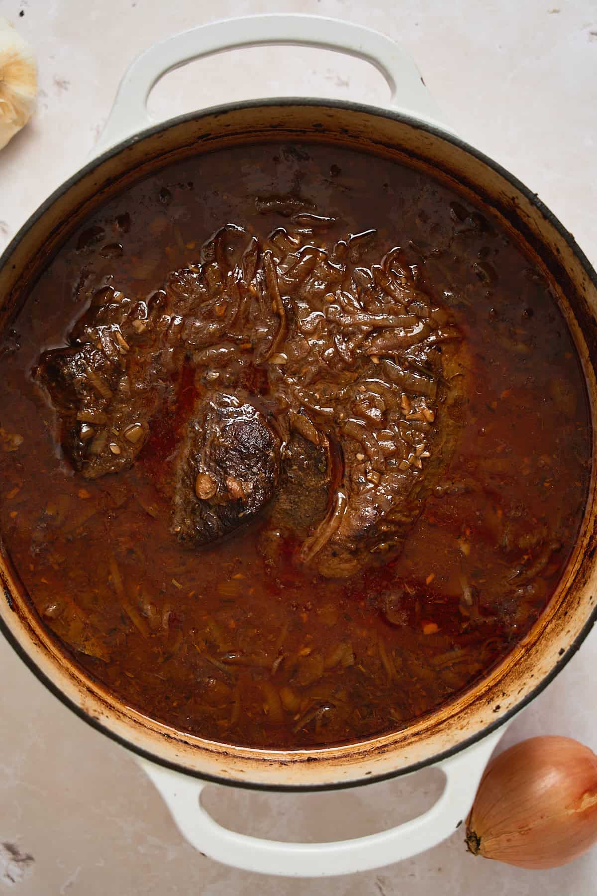 Hearty beef stew in a white pot with a rich, flavorful broth and tender meat. Perfect comfort food for cozy meals.