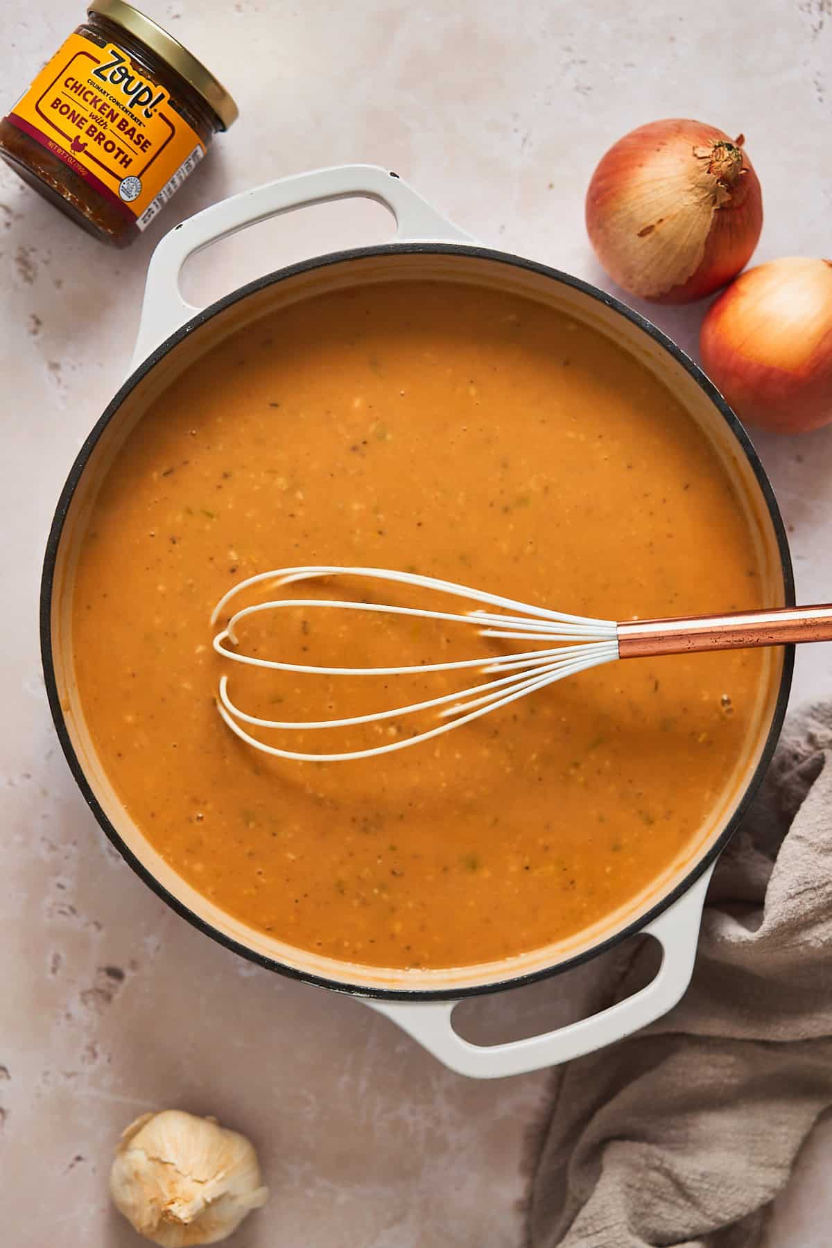Gravy beginning to form in a saucepan made with turkey drippings, cream, and bone broth.