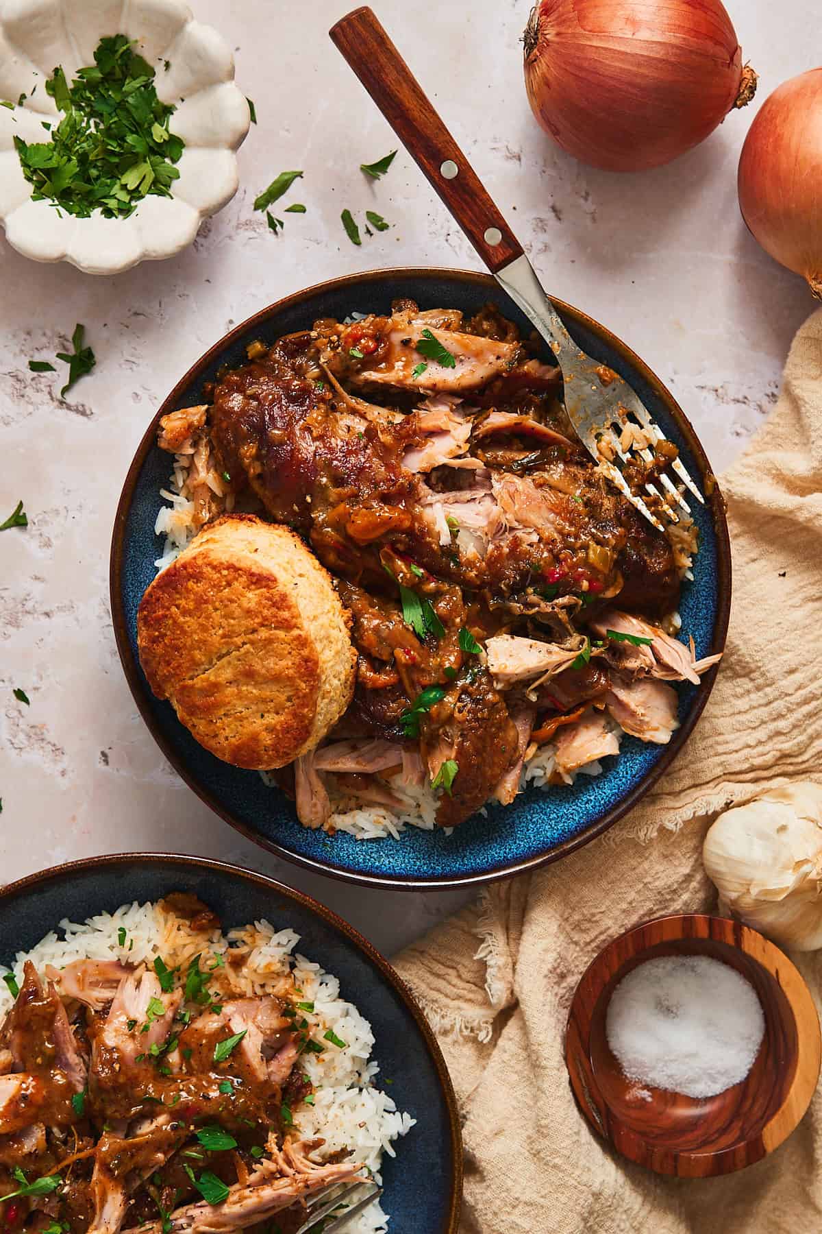 Blue bowls with rice and smothered turkey wings split open to reveal the tender, juicy interior.