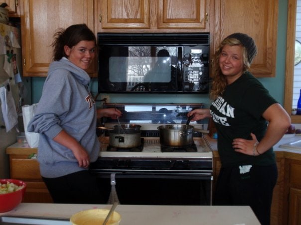 Two women cooking in a small kitchen.