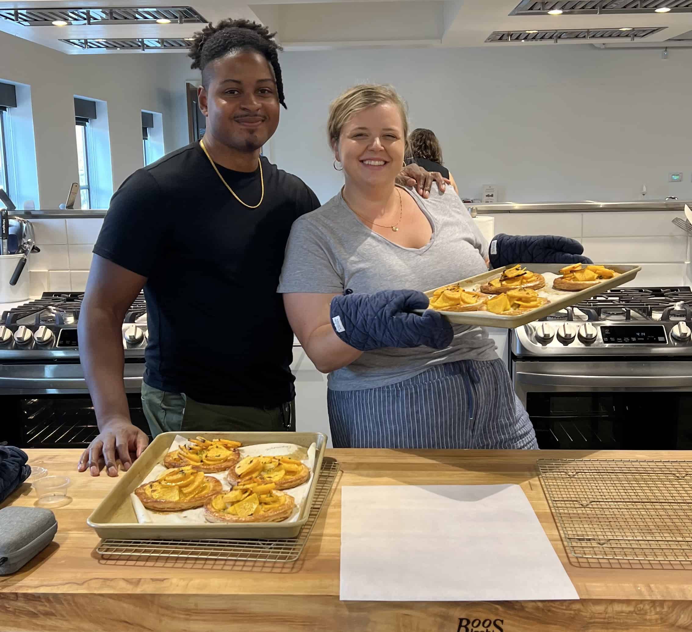 Briana and Chamere in the Bake From Scratch Test Kitchen holding homemade butternut squash puff pastries.