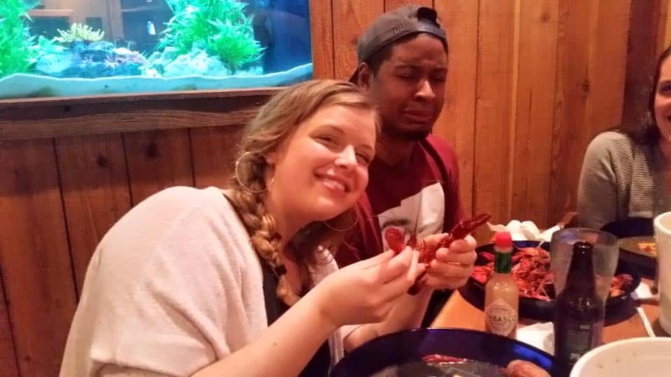 Briana and Chamere being silly while eating crawfish in Louisiana at a restaurant.