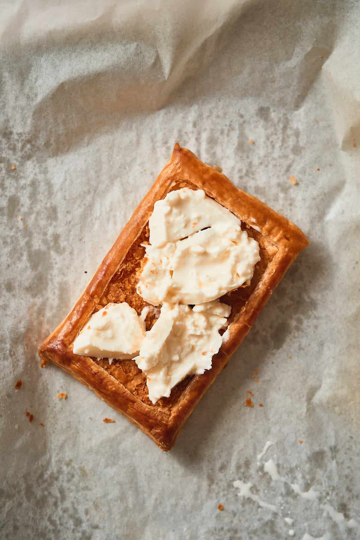 Golden brown puff pastry square filled with warm burrata.