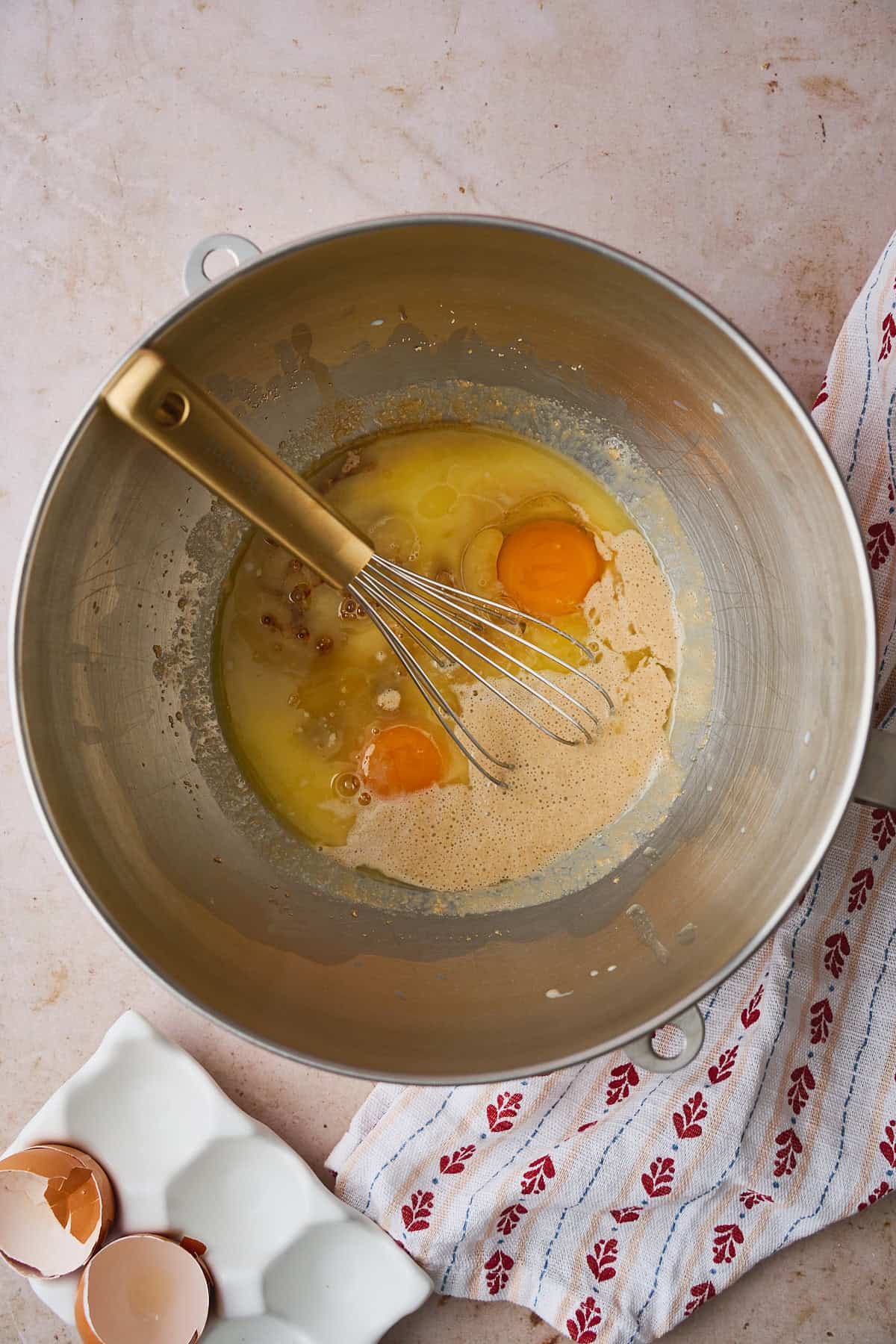 Eggs, butter, and vanilla added to a bowl with yeast and sugar.