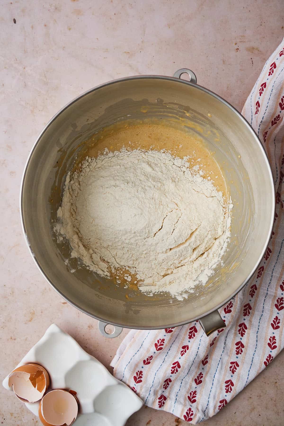 Dry ingredients added to wet ingredients in the bowl of a stand mixer.