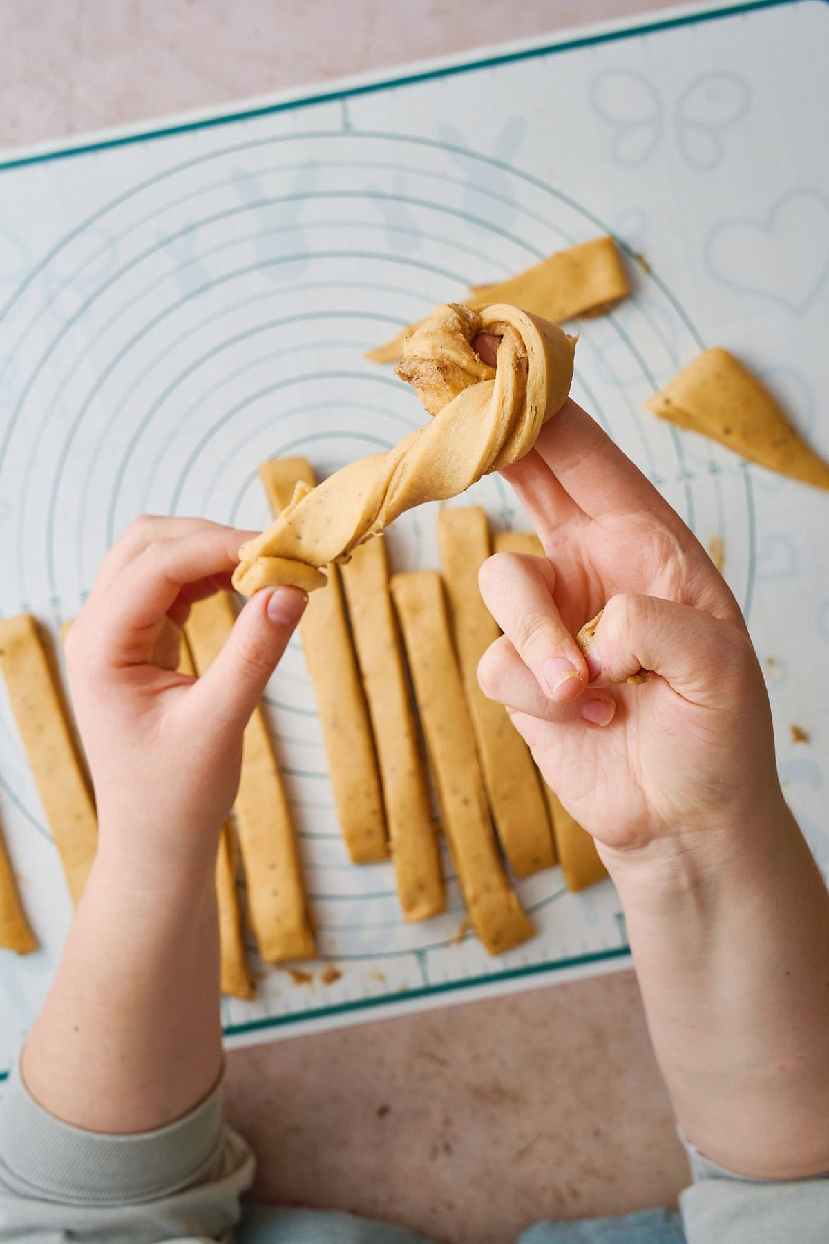 Twisting a knot shape of dough around two fingers.