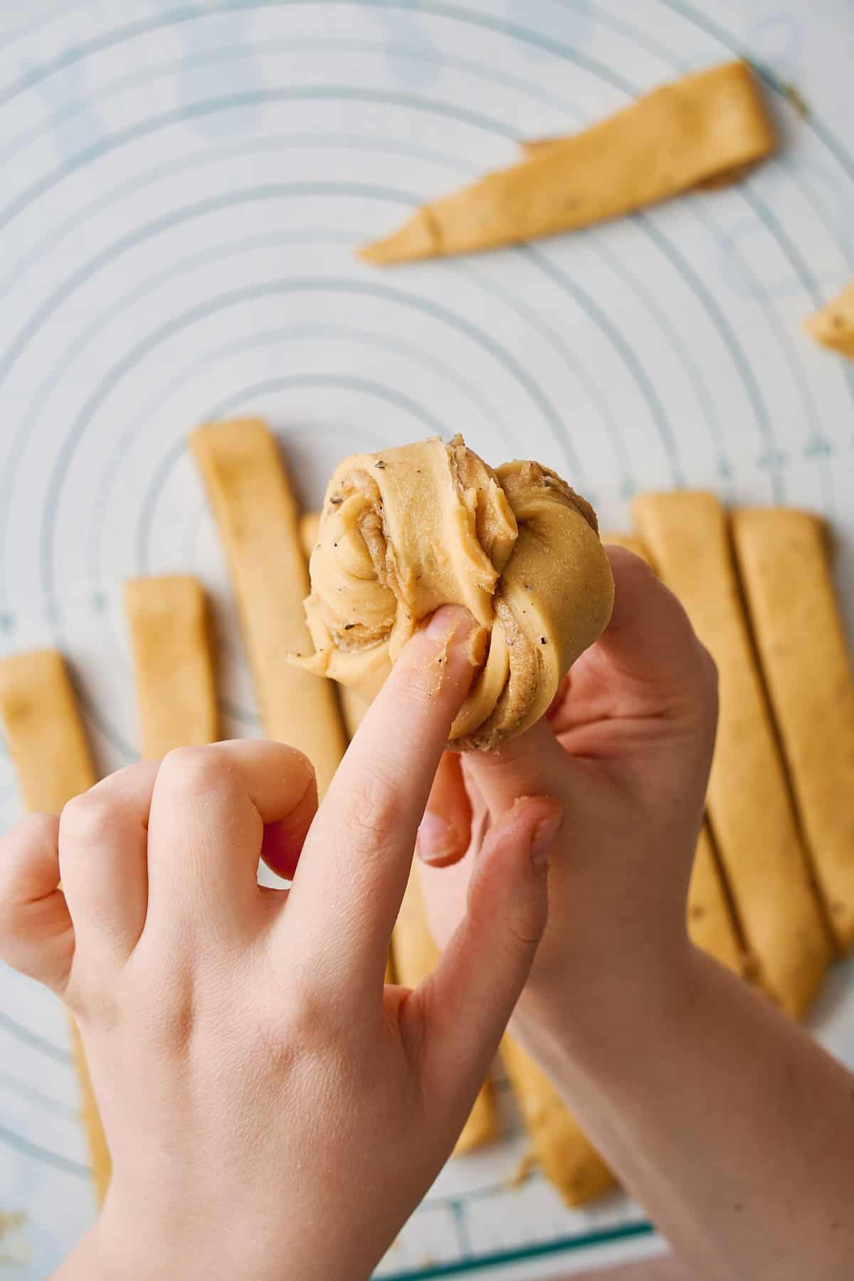 Close up of pressing the end of the knot down inside of center of the cardamom knot.