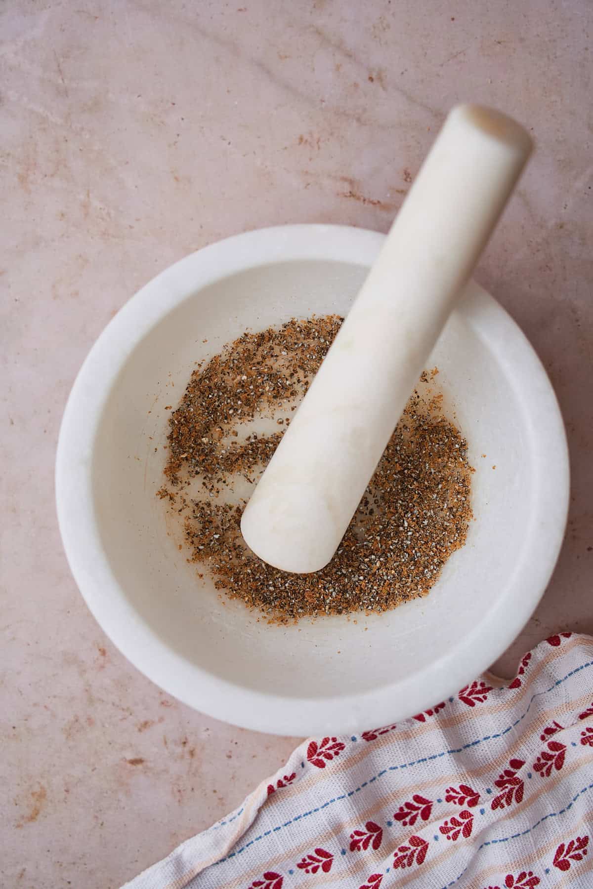 Ground fresh cardamom in a mortar and pestle.