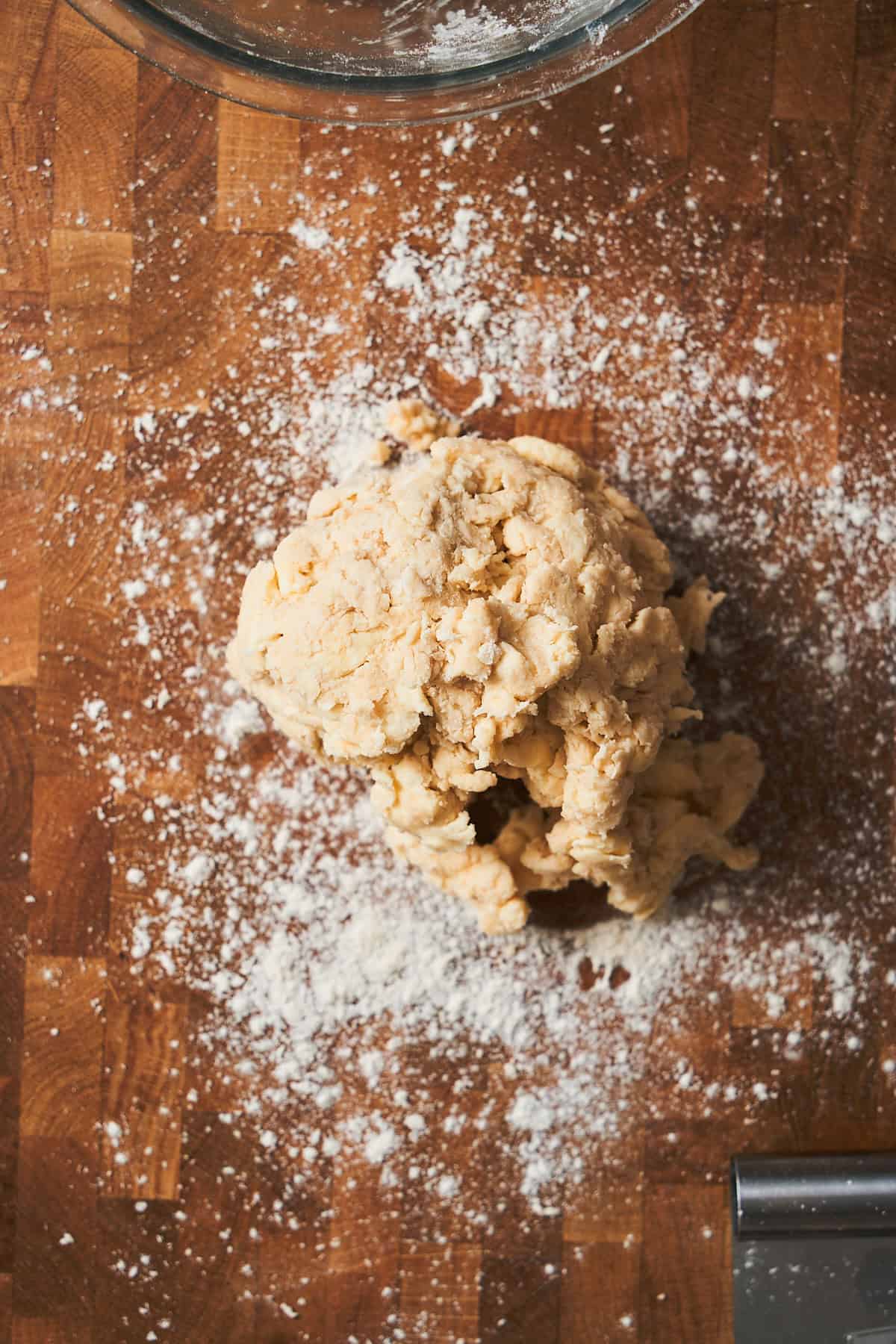 Ball of roughly made dough on a floured surface.
