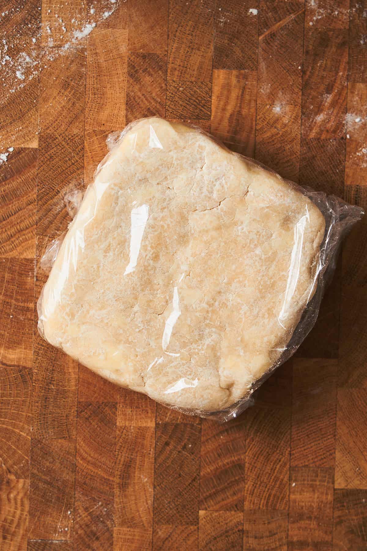 Block of dough wrapped in plastic.