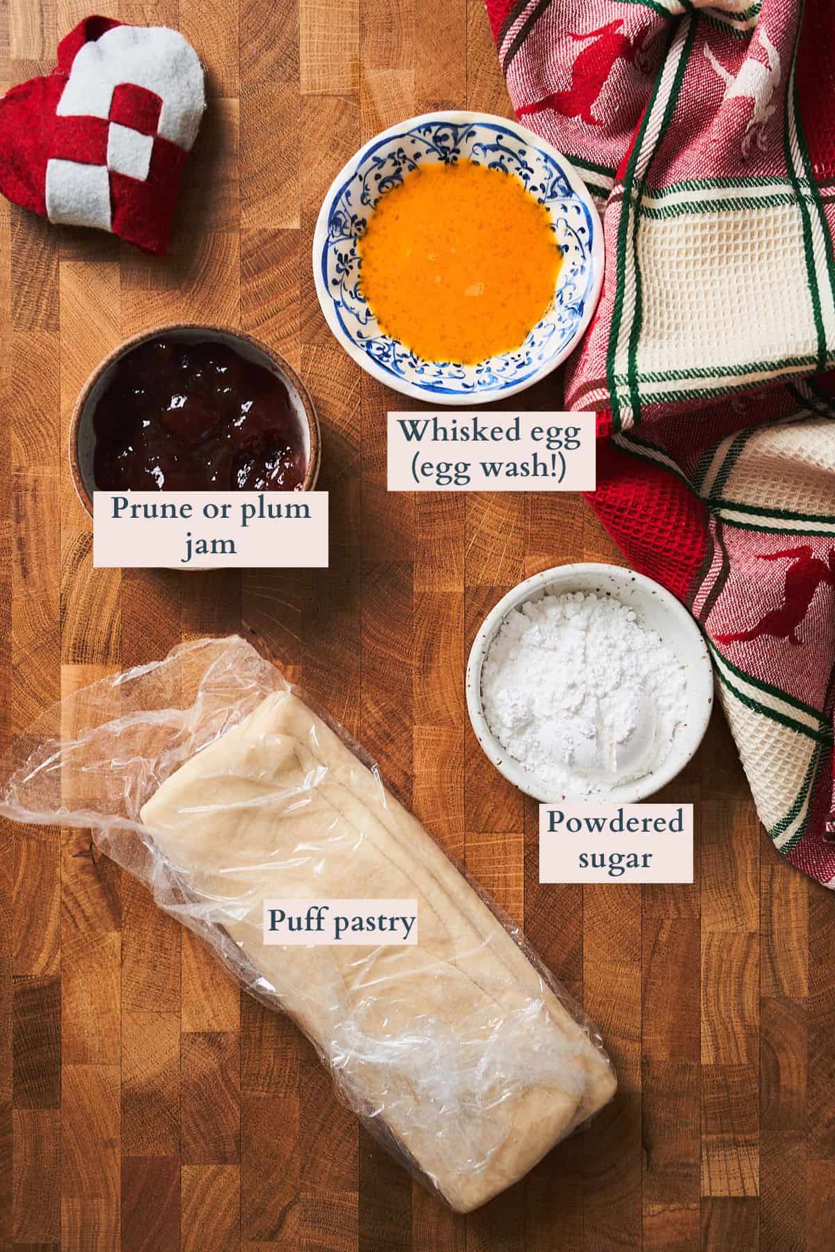 Ingredients to make Finnish Christmas Stars laid out on a wooden table with a patterned christmas linen nearby.