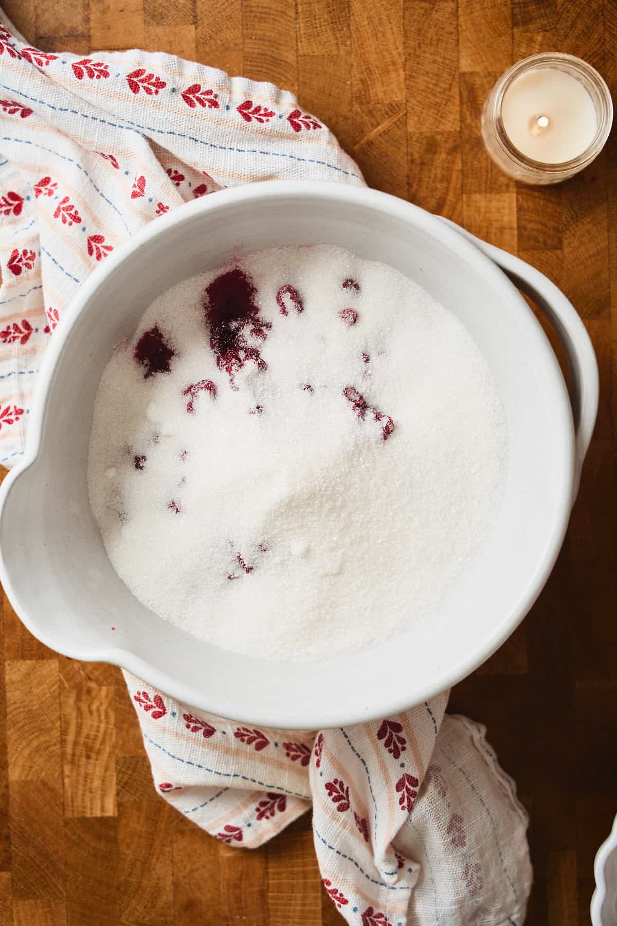 Lingonberries covered in sugar in a bowl.