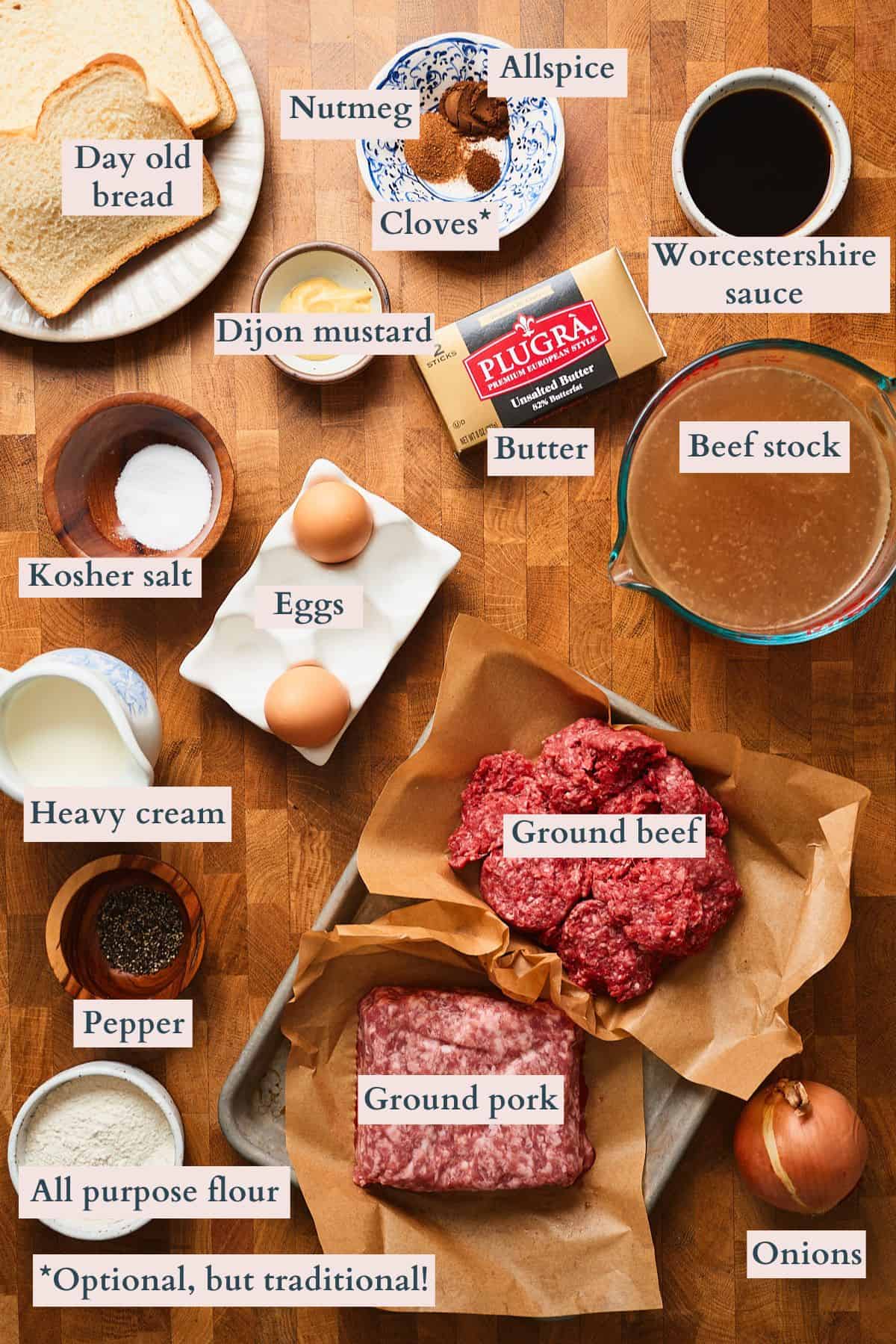 Ingredients to make Swedish meatballs laid out on a wooden table and labeled to denote each ingredient.
