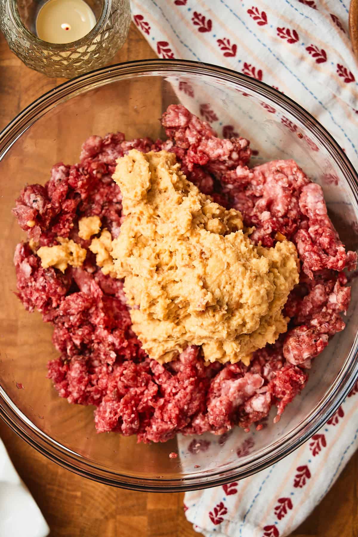 Raw meat in a bowl with mushy bread crumbs added.