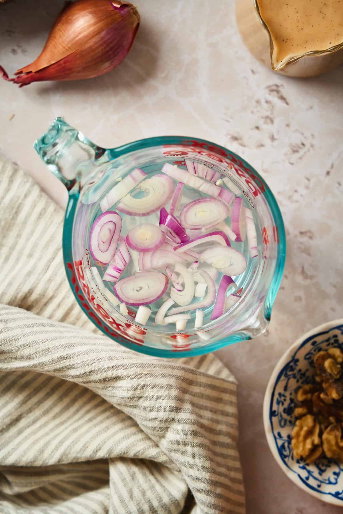 Sliced shallots in water.