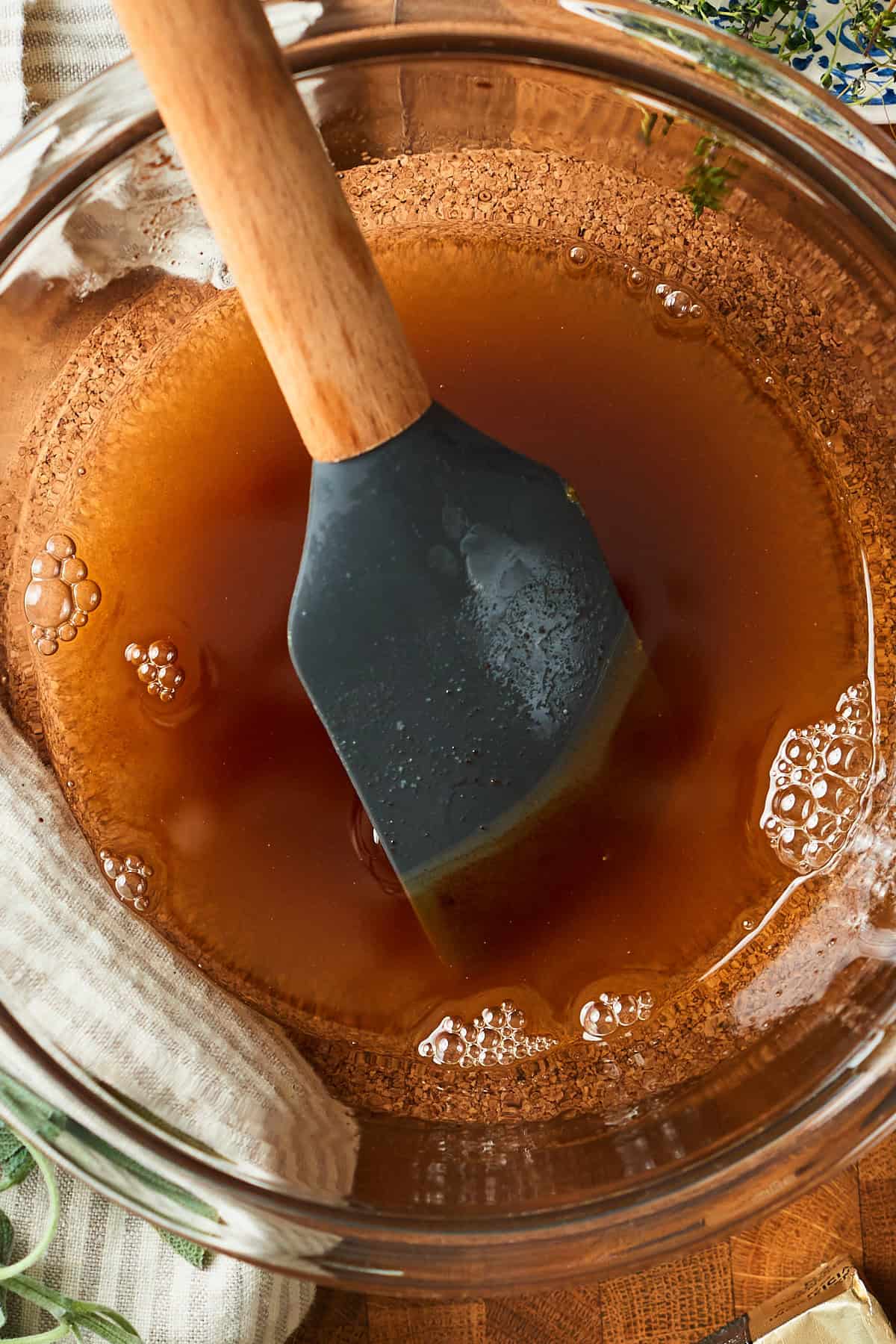 Perfectly browned butter in a glass bowl with a rubber spatula.