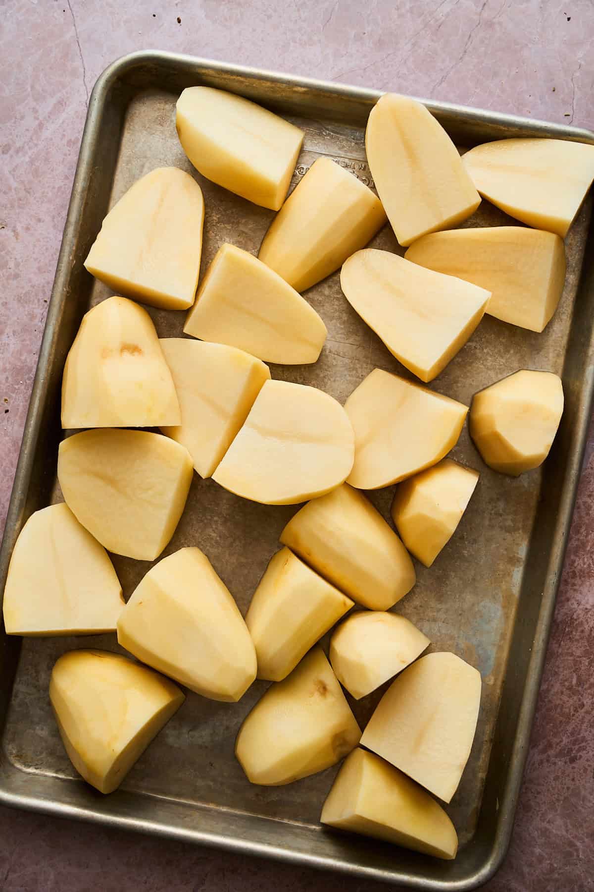 large potato chunks on a baking sheet.