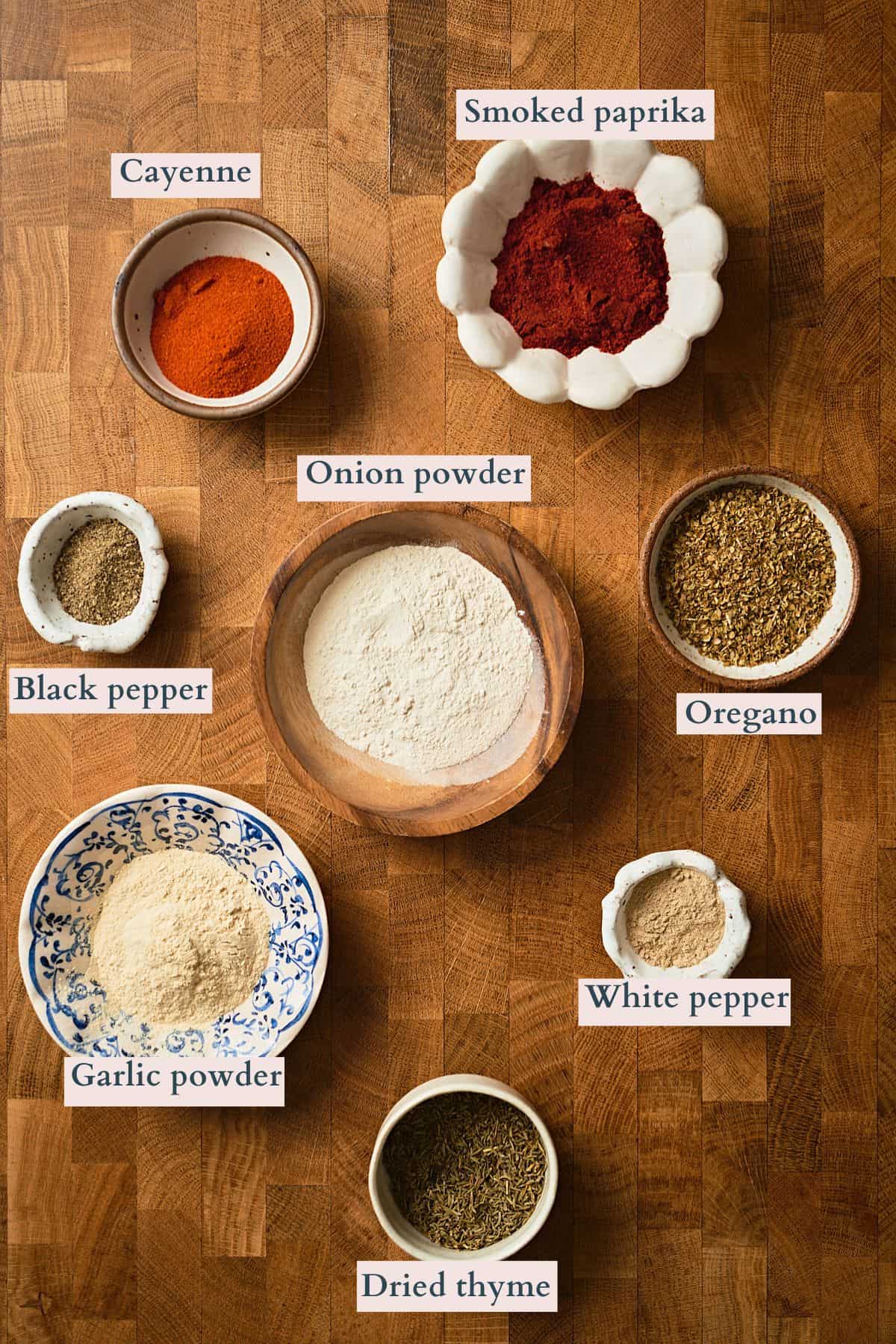 Ingredients to make cajun seasoning mix laid out and labeled to denote each ingredient.