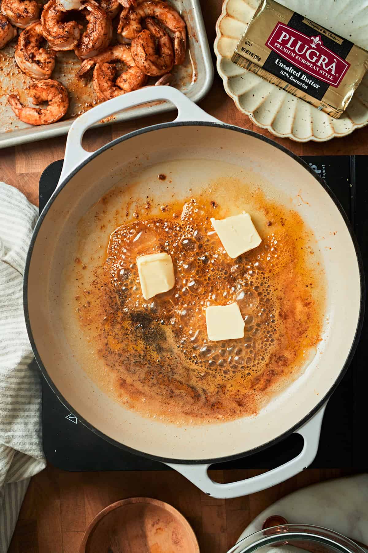 Adding butter to a skillet to melt with browned bits and seasoning