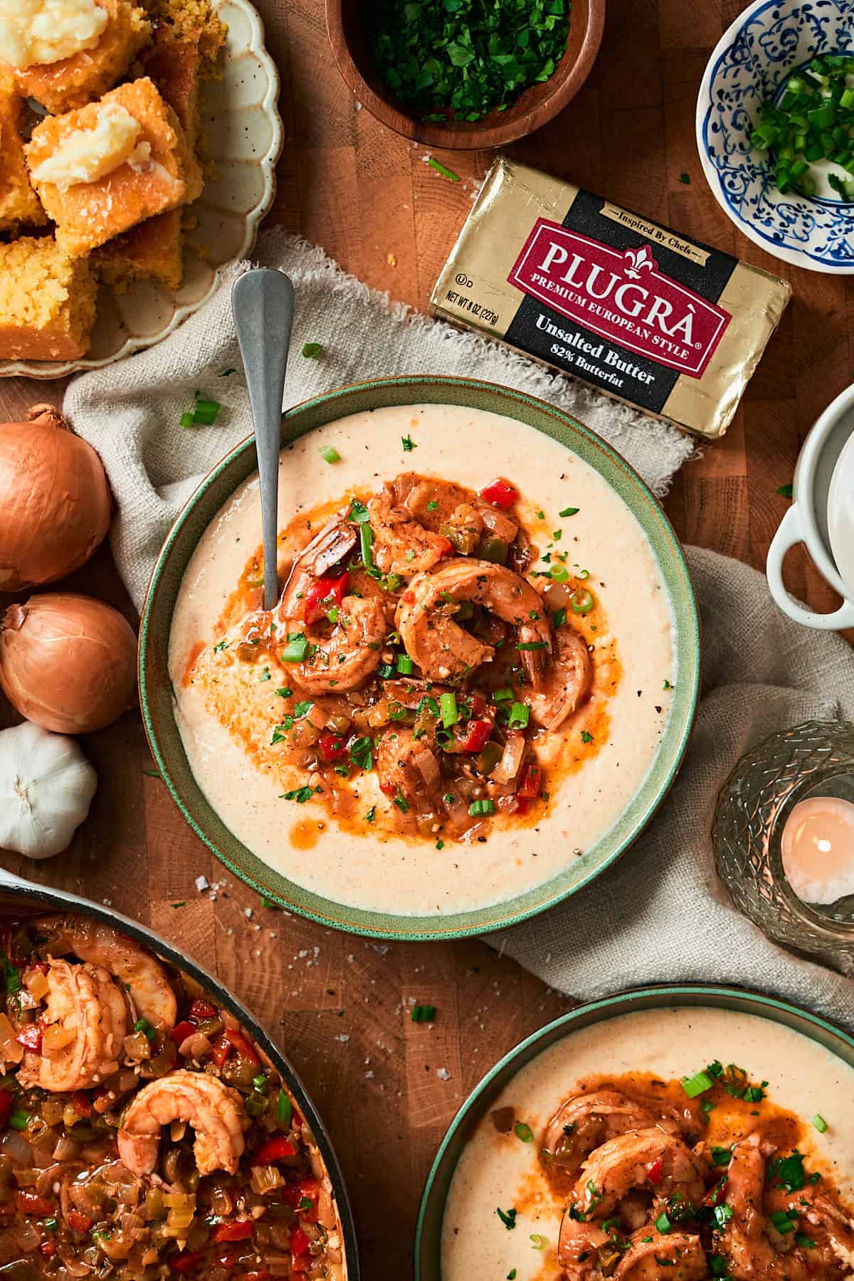 Lovely overhead shot of a green bowl filled with creamy gits and topped with juicy Cajun shrimp.