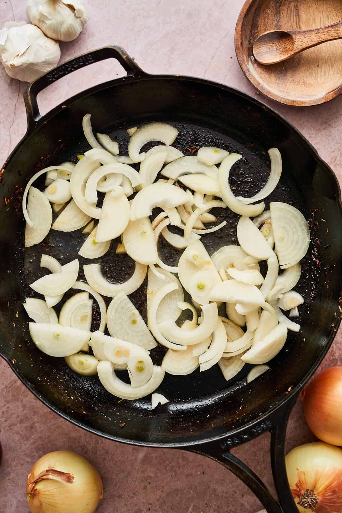 Raw sliced onions in a cast iron skillet.