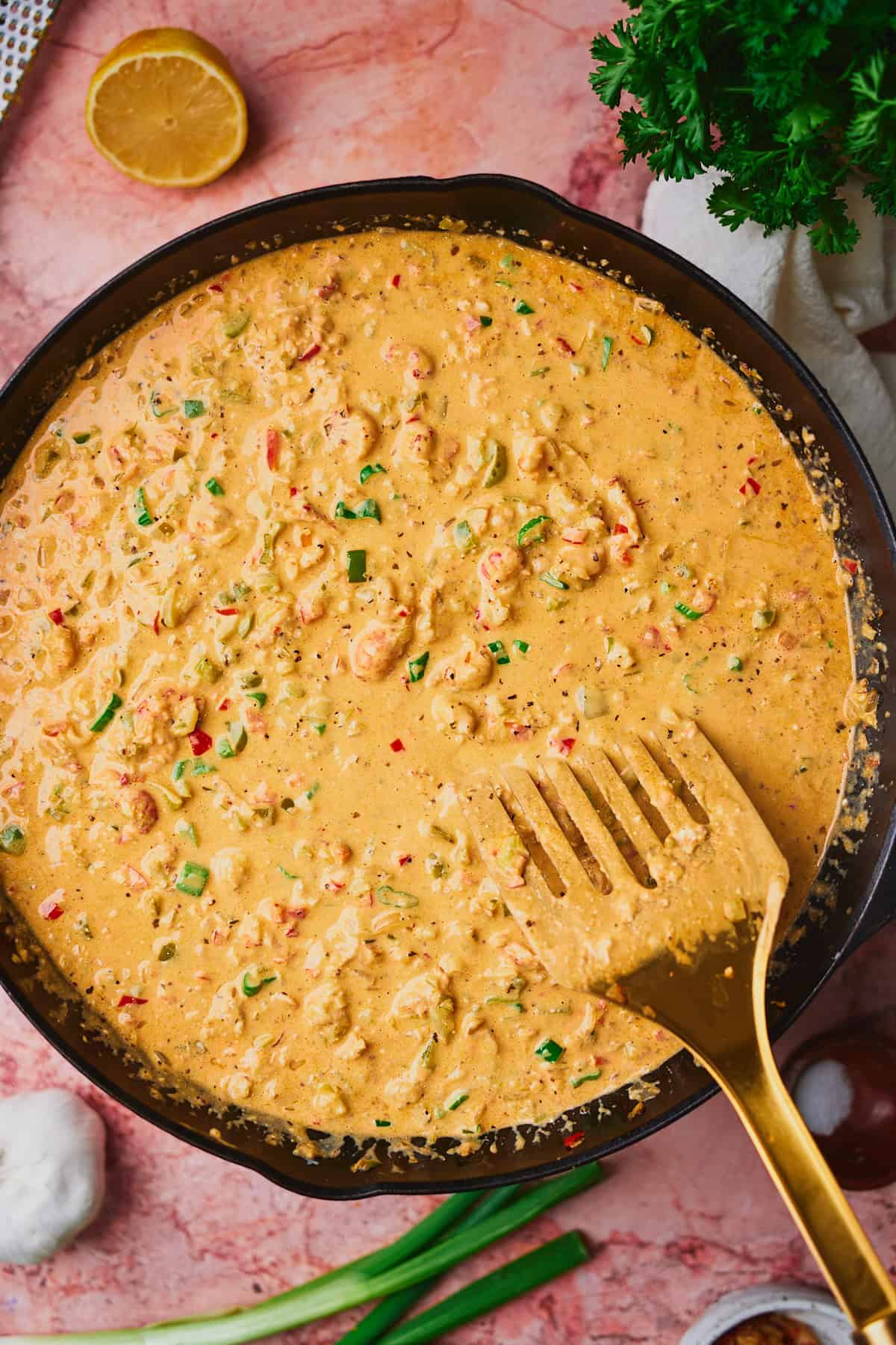 Smooth and creamy crawfish dip in a cast iron skillet with a spatula in the skillet.